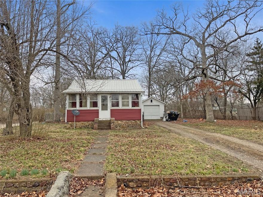 Looking for a mini vacation home or primary residence with a lake view? The enclosed front porch gives you perfect views of the lake. A large sunroom off the kitchen is the perfect place to enjoy your meals. The fenced yard and oversized, detached one-car garage are a huge bonus here. There is plenty of space for a garden beyond the fenced yard. A stone built-in BBQ is in the rear. The lake boasts great fishing, and the dam has just been rebuilt. There is a beach for swimming, a pavilion for picnics, and swings for playing—all within steps of this great little house. A few updates to the house will make it shine. The basement has a sump pump that may need repair or replacement. The basement is wet. Fireplace appears to be non-functional. Property is being sold in its current condition. More about Iron Mountain Lake: https://ironmountainlake.com/about/.