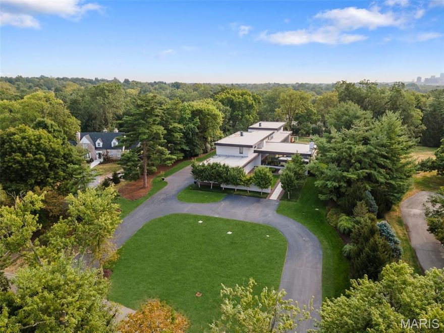 Secluded on a private lane in Ladue, this rare, 12-year-old modern architectural gem boasts over 10,000 sq ft with floor-to-ceiling windows flooding the home with natural light, accented by 14 ft ceilings and high end finishes throughout. The sophisticated great room is perfect for entertaining, while the art gallery with bar area provides additional options for your guests.  The brand new custom kitchen and walk in pantry offer integrated appliances behind custom cabinetry.  Cleverly separated from the entertaining spaces, the private family living area offers a tranquil retreat featuring a main flr luxury suite with sitting room and his/her closets.   Find 4 bedrm suites and laundry on the 2nd level.  The lower level showcases a 2-lane bowling alley, media rm, large rec room with wetbar and a bedrm suite. Walk out to the saltwater pool and covered patio with fire feature.  An indoor half-court basketball/pickleball court is perfect for a pickup game.  A 4-car garage, generator and more.   An indoor half court basketball/pickleball court is perfect for a pickup game.  This home is a perfect setting for an art collection..