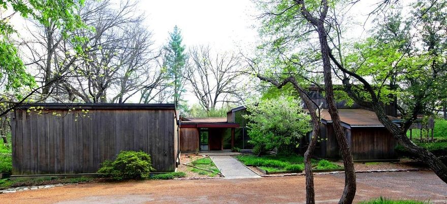 Designed by visionary architect Robert Elkington in 1967, this stunning contemporary estate home is set on a lushly wooded 2.4 acre lot on one of Ladue’s most sought after streets. Huge windows throughout allow you to enjoy the beauty and serenity of the grounds while the large, open and highly flexible floor plan is ideal for both comfortable living and effortless entertaining. Custom features like wide board plank floors, slate topped built-ins and book shelves designed by Jean Paul Mutrux are both timeless and functional. The luxurious 1st floor master suite offers his and her baths, his and her dressing rooms and a multi-purpose space that could be utilized as a studio, home gym or office. Two additional 1st floor bedrooms are located in their own wing & share a hall bath while a private 2nd floor suite includes a full bath and dressing room. Extensive decking and large pool provide tranquility and privacy for hot St. Louis summers & a fabulous outdoor party venue.
