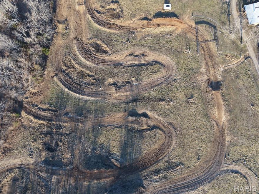 The land lays level to gently rolling and offers an excellent mix of terrain—approximately 80 acres open with the balance in a healthy blend of young and mature timber. Thick cover, natural browse, and multiple water sources create strong habitat for whitetail deer, turkey, and small game. With ponds and a seasonal stream, you’ll have dependable water and plenty of scenic places to hunt, camp, or simply enjoy the outdoors.
Improvements include a 30' x 50' shop with a concrete floor, finished office space and kitchenette on one end, plus a 14' x 50' lean-to. There is a well on the property and fiber internet available, making it easy to stay connected while enjoying the country. You’ll also find an antique gambrel-roof barn with ample storage, a public restroom building, and an older house (not livable).

A standout feature is the restored motocross track, which features hairpin turns, big jumps, a spectator bridge, an announcer/scoring house, a 40-man starting gate, a gate house and plenty of room for parking and camping. The track has a history as a Loretta Lynn regional qualifier and has been used for hosted races.
If your interests do not include motocross racing, the track area can simply be reclaimed and converted back into pasture, giving you even more open ground for hay, grazing, or other uses.

Whether you’re after a hunt-ready Ozark tract, a recreation headquarters, or a property with genuine event potential, this acreage delivers space, access, and versatility.

Property Features: 
• 155+/- acres in Oregon County in the heart of the Ozarks with no restrictions and state-maintained highway frontage.
• Located just a few miles from a major U.S. highway, offering quick, convenient access.
• Terrain is level to gently rolling, making it easy to navigate and use for multiple purposes.
• Land mix includes ~80 acres open with the remainder in a healthy blend of young and mature timber.
• Strong wildlife habitat with thick cover, natural browse, and multiple water sources supporting whitetail deer, turkey, and small game.
• Ponds and an on-site stream provide dependable water and scenic spots to hunt, camp, and enjoy the outdoors.
• Improvements include a 30' x 50' shop with concrete floor and finished living quarters on one end.
• Additional structures include a 14' x 50' lean-to, antique gambrel-roof barn for storage, a public restroom building, and an older house (not livable).
• Utilities/connection: well on the property and fiber internet available for staying connected.
• Major recreation/event feature: restored motocross track with hairpin turns, big jumps, spectator bridge, announcer/scoring house, 40-man starting gate, gate house, plus ample parking and camping, with history as a Loretta Lynn regional qualifier and hosted races.