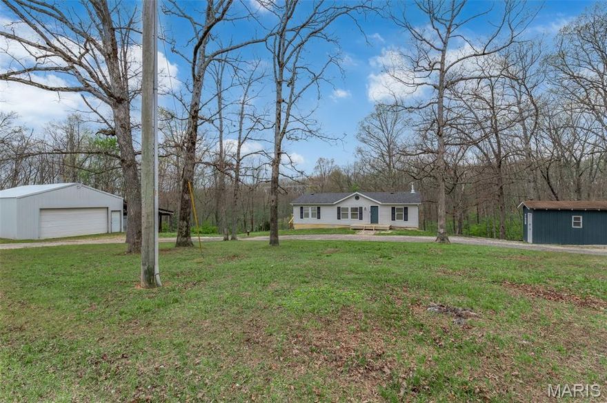 Ranch home with a Split Bedroom Floor Plan with a Deep Pour Walkout Lower Level on 5.49 +/- Acres.  Let your mini-farm life start right here!  Check out the mature deer photos too!  Gorgeous acreage and a nice home with a walkout lower level.  There's a detached 30x24 Garage Outbuilding with an attached lean-to area for a stable or shelter area.  There is also a detached 12x10 workshop and a metal utility shed.  Step inside to a large vaulted great room area with open floor plan from the great room to the kitchen and breakfast bar to the dining room.  There is also a space for an office area off the side of the huge great room.  Main floor laundry room comes complete with a washer and dryer.  The kitchen has black and stainless steel appliances, including the refrigerator, and the dishwasher is new!  Primary bedroom with En Suite has a soaking tub and separate shower and beautiful oversize vanity, mirror and updated lighting.  Bedroom two is next to the hallway bathroom.  Walkout deep pour lower level is awaiting your finishing touches for you to customize and there is a rough-in for a third full bathroom.  There is also a wood burning stove in the basement.  There is a nice deck off of the main floor to view the peaceful acreage and BBQ.  Unincorporated area so no city taxes!  Warrenton R-III Schools.  Easy access to Highway 70.  You've found your new home or maybe even your new weekend getaway place if you are looking for a quiet, peaceful retreat.  Refrigerator, Washer, Dryer, TV over breakfast bar, Sofa and barstools can be included if desired.  (New Roof in 2024 - New deck in 2026 - and a newer water heater too.)