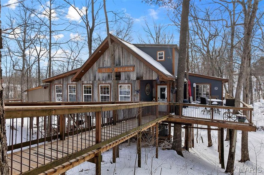 Welcome to this beautiful and truly unique property in a fantastic location, offering privacy, character, and endless opportunity. As you arrive, a private drive leads you to a stunning cedar-wrapped home highlighted by a large porch and expansive windows that bring the outdoors in.  Inside, you’ll immediately appreciate the craftsmanship with rustic wood beams, vaulted pinewood ceilings, and a striking stone wood-burning fireplace anchoring the open floor plan. The main-level provides an open floor plan with kitchen and dining room combo, primary bedroom that features a spacious tile shower, along with the convenience of main-level laundry. Upstairs offers two additional bedrooms and a full bathroom. The fully finished walk-out basement expands your living space with a large family room, fourth bedroom, two bonus rooms, and a full bathroom—perfect for guests, hobbies, or multi-generational living.  Recent upgrades include a new roof, exterior wood siding freshly stained in 2025, and meticulous ongoing maintenance throughout the home. Next to the 2 car garage you'll notice a major bonus for comfort and efficiency is the wood-burning stove that efficiently heats the entire home, providing exceptional warmth during colder months.

In addition to the residence, the property includes a remarkable second building styled as a Treehouse. This 2,500+ sq. ft. space features rustic wood ceilings, barn wood accent walls, large windows, and a stunning 30 x 40 private wood deck surrounded by trees, creating a peaceful and inviting setting. The building includes a commercial-style kitchen, dish room, full bar, two bathrooms, and ample storage. With its layout and setting, it offers incredible potential for revenue generating opportunities for special events such as weddings, parties, restaurant, bar, or even a potential Airbnb.

The property also includes an existing shop and footings already poured for a 40 x 50 shop near the main road, adding even more flexibility and value.

This is a rare opportunity to own a one-of-a-kind property that blends rustic luxury, functionality, and income-producing potential—all in one exceptional setting.