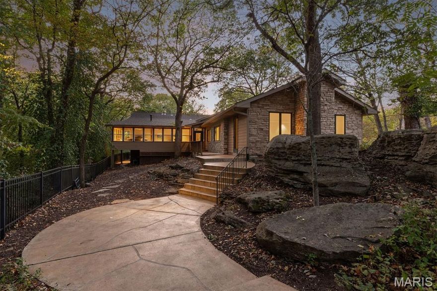 A genuine hidden sanctuary in the heart of Kirkwood, this privately gated Sugar Creek estate offers a rare blend of architectural elegance, wooded privacy, and resort-style amenities on over 3 acres. Tall vaulted ceilings, eye-catching Solistone tile accent walls, and expansive glass walls fill the interiors with natural light. The sleek Euro-style kitchen is outfitted with top-tier SubZero, Viking, and Dacor appliances, perfect for upscale entertaining and daily living. The vaulted main bedroom features dual custom closets, a gas fireplace, and a spa-like bath with a steam shower and oversized Whirlpool tub. Three additional bedrooms, all with walk-in closets, are complemented by a full and half bathroom. A versatile space above the three-car garage serves as a game room, studio, or extra living area. Other highlights include a cedar-lined sun porch, a spacious bonus/game room, and whole-home smart lighting and audio. Outdoors, enjoy a peaceful reflection pond, stone patios, a built-in grill, and a resort-style pool. Located moments from downtown Kirkwood’s charming center, yet a world apart.
