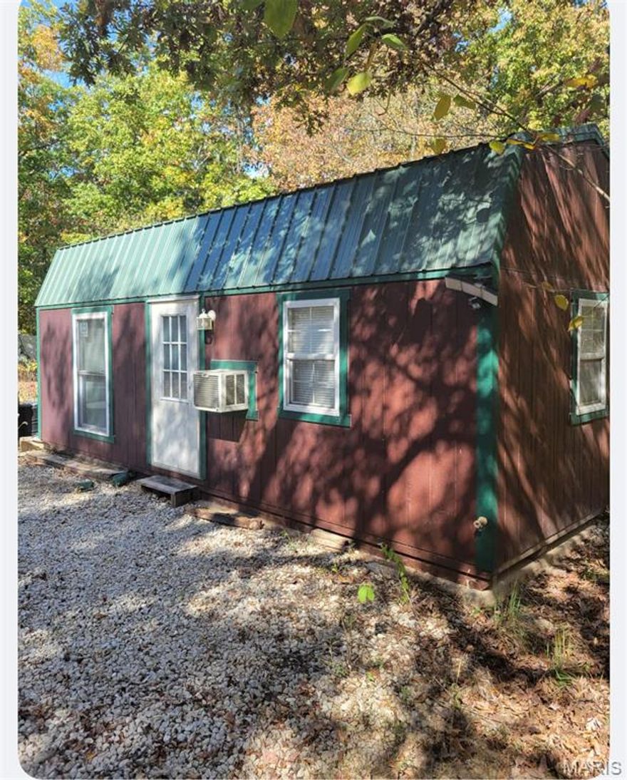 OPPORTUNITIES ARE ENDLESS...
A CHANCE TO OWN 5 TRANQUIL ACRES.  ACCESS TO FISHING LAKES AND A PRIVATE ACCESS TO BIG RIVER.  COME ENJOY A  PICTURESQUE WATERFALL, ROLLING HILLS, THE PEACEFUL SOUND OF THE BIG RIVER FLOWING CONTINUOUSLY WITHIN THE DEVELOPMENT.  THE CABIN IS ON A CONCRETE SLAB WITH ELCTRICAL WIRING AND PLUMBING READY FOR HOOKUP.  THE BEDROOM IS CLOSED OFF FOR PRIVACY AND THE FULL BATHROOM WAS COMPLETELY REDONE.  THE HOT WATER HEATER WAS JUST PUT IN AND READY FOR CONNECTION.  THE BATHROOM SETUP IS BRAND NEW WITH A FULL SHOWER/TUB.  A QUAINT LITTLE SITTING AREA TO SIT AND RELAX AND A FUN LOFT FOR EXTRA SLEEPING SPACE.  THERE IS A CAMPER WITH A SEWER HOOKUP. THE CAMPER HAS SOME DAMAGE FROM A TREE LIMB BUT COULD BE REPAIRED.  A 250 GALLON WATER STORAGE IS ACCESSIBLE TO THE CAMPER.  
BUILD A HOME WITH A VIEW, OR USE AS A GETAWAY WITH ACCESS TO THE BIG RIVER. POSSIBILITIES ARE ENDLESS...