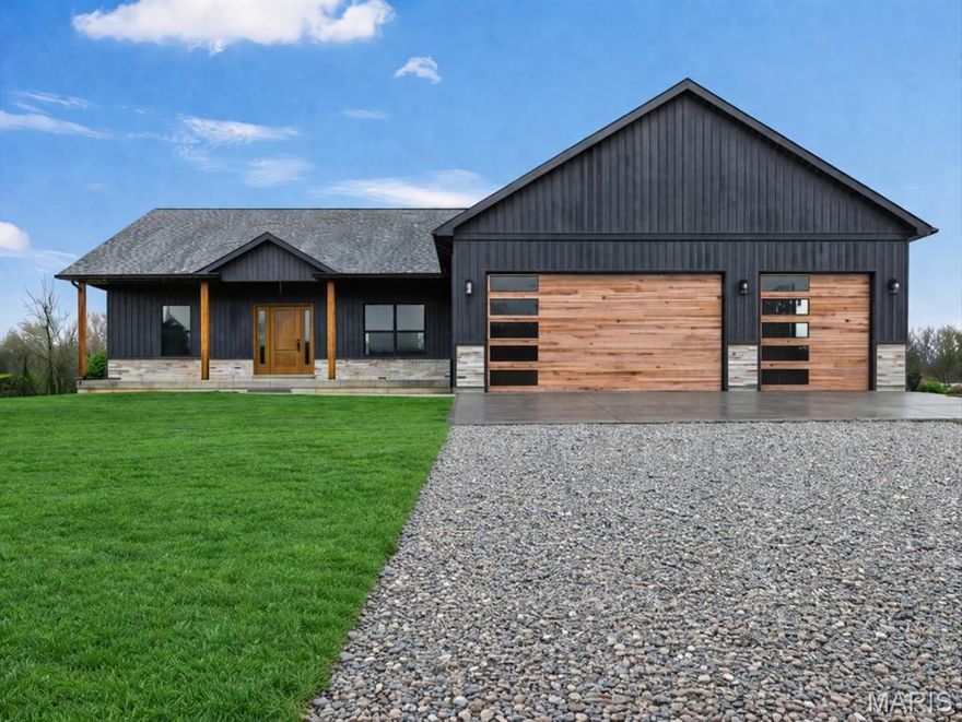 Stunning New Construction Ranch on 3 Acres in Jonesburg! Welcome home to this beautifully constructed new construction ranch nestled on a peaceful 3-acre lot in Jonesburg, MO. Offering 3 bedrooms, 2 full bathrooms, and a spacious 3-car garage, this home perfectly blends modern finishes with functional design and room to grow. Step inside to discover 9-foot ceilings, an open and airy floor plan, and custom 52” soft-close cabinetry paired with gorgeous quartz countertops throughout the kitchen and bathrooms. The thoughtfully designed divided bedroom layout offers privacy for the primary suite while keeping the secondary bedrooms comfortably separated. The primary suite is a true retreat featuring a coffered ceiling, large walk-in closet, and a luxurious en-suite bathroom with double vanity, walk-in tiled shower, and separate garden tub. The full unfinished basement offers incredible potential with wide staircase access, egress window, and rough-in plumbing, making it ready for your future finishing ideas. A standout feature is the 30x5 safe room located under the front porch, complete with a fire-resistant door and electricity—perfect for storage or security. Enjoy outdoor living on the full-length front porch with recessed lighting and dedicated Christmas light outlet, or relax on the stunning covered back patio featuring recessed lighting and a ceiling fan. A convenient sidewalk connects the back patio to the front of the home for easy access. Situated on 3 beautiful acres, this property offers plenty of space for outdoor enjoyment and room to build a shop or additional outbuilding. If you’re looking for new construction, privacy, and modern farmhouse charm with room to grow, this home checks all the boxes. Book your appointment today!