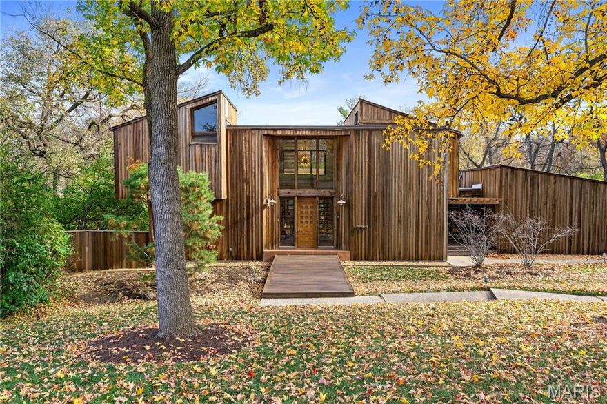 This redwood-clad contemporary, designed by architect Charles E. Fleming as his own modern sanctuary, radiates coolness! Completely renovated yet true to its original spirit, the home seamlessly connects to nature through walls of windows and outdoor spaces that make the private 1.12-acre setting feel like a modern treehouse retreat. A dramatic two-story foyer opens to a warm, tree-lined living room with a fireplace and deck access. The reimagined kitchen pairs a large island with sleek oak cabinetry, stainless steel appliances, and a butler's pantry. Another large flexible space at the front of the home would make a perfect formal dining room and living room. Upstairs, the light-filled primary suite features a skylit bath and a walk-in closet with built-in storage. Two additional bedrooms and a bathroom complete the second level. The original spiral staircase leads to a walkout lower level featuring a recreation room with a bar, a bedroom, a bath, and a laundry room with a dog wash. Walkout access leads to the covered patio with a fireplace that steps out to the pool, hot tub, and putting green. A bridge leads you over the pool to the guest house apartment, which includes a sauna, kitchenette, circular dome window, and a two-car garage. Another bridge in the yard takes you to an almost secret flat lot. An additional two-car garage is attached to the main house.