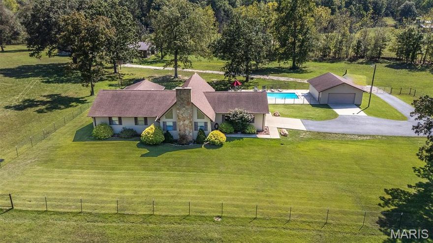 Beautiful ranch style house 5.5 miles from Poplar Bluff.  Country living at its finest.  Asphalt driveway, inground pool, attached garage, detached garage, 2 barns, tack room and shop building with living area inside.  The property adjoins government land with access to hundreds of acres for hunting or riding horses.  The property is fenced and cross fenced and has two ponds.