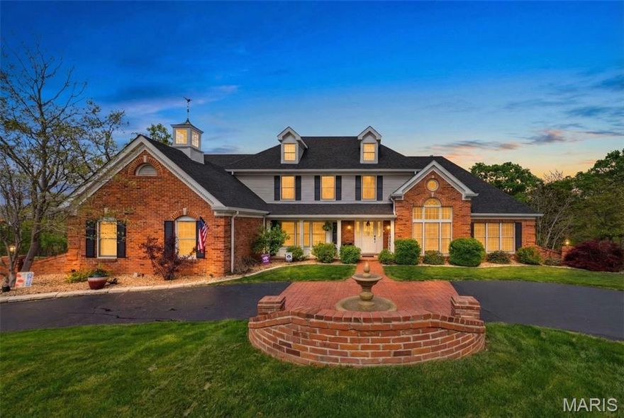 Welcome to this stunning 1.5 story custom home with circle drive, perfectly nestled on an acre lot in a private cul du sac overlooking the Meramec River Valley. Designed with character & charm, the quality craftsmanship of the home is evident with the use of gorgeous detailed millwork & rich materials. A grand two-story marble foyer sets the tone, opening into the custom wood-paneled den with built-in shelving & palladium windows. The dramatic cathedral ceiling great room is impressive with gleaming, hardwood floors, a statement gas fireplace, and an expansive quartz wet bar with glass cabinetry, and complete with wine fridge. The chef’s kitchen is a gathering place, showcasing an abundance of shining quartz counters, a large center island with gas cooktop, and 42in. custom cabinetry, all leading into the sunlit, octagonal breakfast room or alternatively into the elegant formal dining room with herringbone hardwood floors, coffered ceiling & bay window, ideal for entertaining large dinner parties. The main-level primary suite is a spacious retreat with glass french doors leading into the newly renovated, luxurious bath, featuring a spa-inspired soaking tub, dual vanities, custom walk-in closets, and vanity niche. The switchback staircase leads to the upper level featuring a charming loft with built-ins, a second primary suite, and additional bedrooms connected by a Jack-and-Jill bath. The walkout lower level enhances with a spacious family and recreation area with fireplace and direct access to the expansive outdoor patio with hot tub and firepit, perfect for entertaining guests or a game night with family. The lower level also includes a workout room, full bath with steam shower, and a cedar closet, leading out to the 4th garage with rear. From the main level, step outside to a sprawling composite deck where both the breakfast room and great room open to gorgeous, private nature views—perfect for morning coffee or sunset gatherings. The features & updates are too numerous to list! Come experience it for yourself—this is more than a house, make it your next forever retreat.