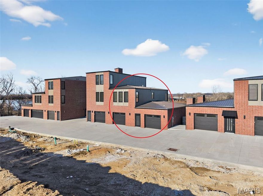 Welcome to The Bluffs at Bassora Place! This extraordinary, modern, 2,540 sq. ft., two-story townhome is perched on a scenic river bluff, where nature meets contemporary living in perfect harmony. From the moment you arrive, the architectural vision becomes unmistakable. Imported tilt-and-turn windows—a European hallmark of innovation & engineering excellence—frame the breathtaking Missouri River views. Every outward glance becomes a living masterpiece as nature’s timeless beauty unfolds before you. Step inside & discover an unwavering commitment to quality at every turn. The wide-open main level showcases true modern living with its seamless living/dining/kitchen design—an entertainer’s dream. Double doors open to an expansive deck, ideal for outdoor dining, hosting guests, or simply watching the boats go by. The kitchen is a standout feature, centered by a massive breakfast bar offering casual dining & abundant under-counter storage. Luminous quartz countertops define the space, while premium included Bosch appliances stand ready for culinary adventures. A well-designed butler’s pantry adds both storage & function—perfect for a coffee station—and cleverly tucks the refrigerator out of sight to maintain clean, uninterrupted kitchen lines. A stylish powder room & a stunning gas fireplace anchor the main living area, casting a warm glow on cool evenings. The lighted staircase guides you to the private upper level, where two luxurious bedroom suites await. The primary bedroom is a sanctuary unto itself. Here, sunrises & sunsets over the river create a beautiful start & end to the day. The ensuite bathroom exceeds all expectations with radiant heated floors—imagine stepping onto warm, sun-kissed tile even on the coldest mornings—along with an exquisitely tiled shower, relaxing soaker tub & double vanity. A thoughtfully designed custom closet system completes the space. An included Electrolux washer & dryer conveniently located in the hall, services both suites with ease. The fully finished walk-out lower level expands your living possibilities & this build includes a THIRD bedroom which can be offered on any other new build if needed. The space can also function as a recreation room, gym or an office—your choice. Large windows ensure brightness, while the second gas fireplace adds cozy sophistication. Step out to the covered patio for additional outdoor enjoyment. Thoughtful upgrades are found throughout: zoned heating & cooling, engineered hardwood floors & a two-car garage equipped with an EV charging station & epoxy flooring are just a sampling of the exceptional features this home offers. The location adds yet another layer of appeal. Mercy Hospital is nearby, as is historic downtown Washington, dining & shopping. The Missouri River Bridge—your gateway to the region’s celebrated wine country & the Katy Trail—is just moments away. This is more than a residence. It is an invitation to live where exceptional craftsmanship meets nature’s majesty. Schedule your private showing today & discover what awaits you at The Bluffs at Bassora Place.