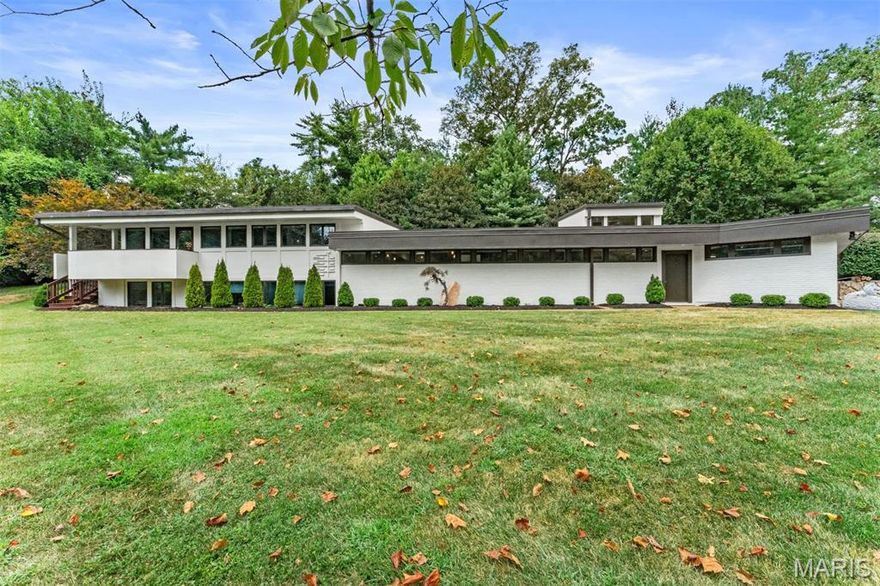 Situated on a private one-acre lot, this stunning mid-century modern home has been updated while maintaining the mid-century aesthetic. Designed by Isador Shank, one of St. Louis' most prominent contemporary architects, this multi-level  home contains numerous gathering spaces both inside and out. The kitchen is highlighted by Poggenpohl cabinetry and Miele appliances and looks out into the great room with views of the yard and pool. A divided floor plan on the lower level allows room for gathering while affording separation between the primary suite and 2 other bedrooms. The primary suite is connected to one of the smaller bedrooms, allowing for nursery space or a home office. Another 3 rooms are available for an office,  sitting area or a game room. A covered patio, salt-water pool  and well-maintained landscaping offer additional space for relaxation no matter the season.
