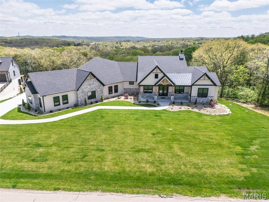 This custom home showcases a beautiful, modern farmhouse-style home with a blend of rustic and contemporary design elements. A standout feature is the inviting front porch supported by wooden columns with timber accents in the gables, creating a warm, welcoming entry. The kitchen features a clean, contemporary design with white shaker cabinets and sleek black slate backsplash. The large central island, topped with pristine white quartz countertops, offers seating for four. The sophisticated stainless-steel appliances, including a double-door refrigerator and a professional grade-range with a statement hood. The adjacent living room is welcoming and spacious. Floor-to-ceiling windows and a sliding glass door flood the area with natural light and open to a deck with expansive views. Massive 5 car garage with half bath! Landscaping, sprinkler system, fence, automatic shades, wired security cameras all complete, just move right in! The backyard is set up perfectly for an inground pool!