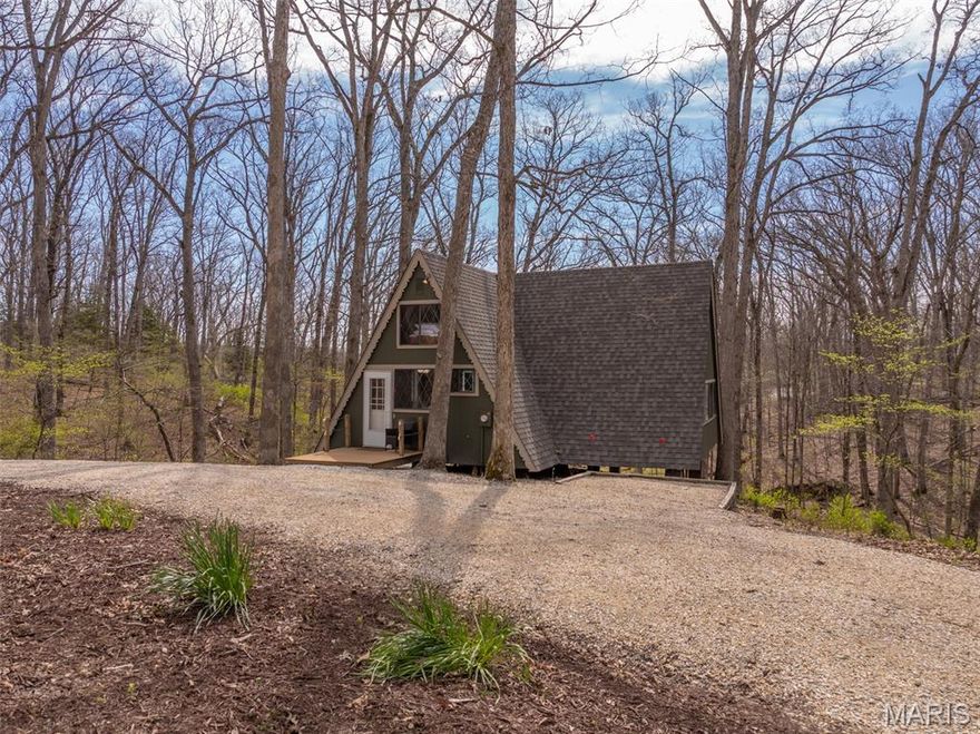 Set on more than three wooded acres, this quintessential A-frame offers a peaceful and serene setting. The winding gravel driveway leads you in and creates a true sense of arrival. Fresh gravel accents the well-maintained approach. Mature oak forest literally picture frames the lake. The exterior has been updated with a newer roof, complete painting, and stained deck. Inside, the home blends the familiar A-frame style with meaningful updates. New flooring runs through the main living areas. The kitchen has been remodeled with a clean, functional layout. The main living room features the signature wall of windows that brings in natural light and frames the wooded views. A wood-burning stove adds comfort during the cooler months. The main floor includes a vaulted primary bedroom and an updated bath. Upstairs, the loft provides additional sleeping space or a workspace. High-speed internet is available, making it easy to stay connected when needed. 
Major systems have been addressed with a newer HVAC system and septic tank. The property includes 52 feet of shoreline on Seebrook Lake. The wooded setting offers privacy, with the option to shape the shoreline to fit your vision over time.
Offered fully furnished and move-in ready, this non-rentable property is set up for immediate use. It is a straightforward, well-maintained retreat in a strong Innsbrook location.