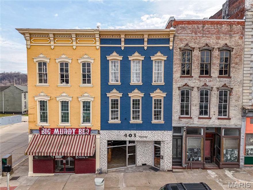 Located in the heart of historic downtown Hannibal, 403 Broadway presents an excellent mixed-use investment or owner-occupant opportunity. This versatile property features two upper-level residential apartments and a flexible commercial space on the main floor, offering the potential for multiple income streams. On the main level, the commercial space offers an open floor plan ready to suit a variety of uses. Whether you envision a retail storefront, café, office, studio, or boutique, this space provides the flexibility to bring your vision to life. It is currently vacant and ready to be leased for additional income or customized for an owner’s business needs. With strong street frontage on Broadway, the property enjoys excellent visibility and convenient access to downtown shops, restaurants, and local attractions.
The upper levels include two separate apartments, both currently occupied by dependable, income-producing tenants, providing immediate cash flow from day one. The second-floor unit offers a two-bedroom, two full bathroom layout, providing strong rental appeal and functional living space. The third-floor unit features a spacious one-bedroom, two-bathroom layout with balcony access off the back—perfect for enjoying a private outdoor space. The kitchen is highlighted by a large quartz island with additional storage, overlooking the open living and dining area to create a functional and inviting layout. The third-floor unit also includes a tile walk-in shower and a soaking tub, adding a touch of comfort and luxury. Both apartments are equipped with in-unit laundry, increasing convenience and tenant desirability.
With built-in rental income, commercial flexibility, and a prime location in one of Hannibal’s most recognizable downtown corridors, 403 Broadway is a strong opportunity for investors, entrepreneurs, or anyone looking to be part of the city’s vibrant business community.