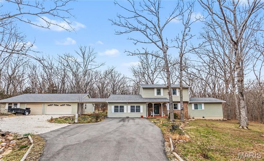 Discover the perfect blend of privacy and convenience with this spacious 5 bedroom, 3.5 bathroom home nestled on 2.55 secluded acres—yet still just minutes from everything you need. Just a short drive to Oak Meadow Country Club, shopping, or the interstate, It's hard to beat this location! Inside, you’ll find both a formal living room and formal dining room, ideal for hosting gatherings or enjoying quiet evenings. A separate den offers a cozy, log-cabin feel with its wood-burning stove, creating a warm and inviting space for relaxing. The main-level master suite provides comfort and luxury with its beautifully tiled shower and thoughtfully designed layout. Upstairs, four additional bedrooms and 2 full bathrooms offer plenty of room for family or guests. Outside, the property shines with a detached 36x46’ three-car garage that includes a workshop and storm shelter, providing both functionality and peace of mind. A circle driveway welcomes you home and adds easy access, while the beautifully maintained flower beds bring color and charm to the landscape. Enjoy the outdoors from the screened-in back patio or the large deck—both surrounded by mature trees that provide privacy and cool shade throughout the summer. New Roof installed March 2026! This unique property has all the space, character, and amenities you’ve been looking for!