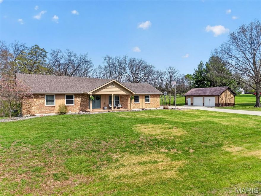 Welcome to this beautiful, brick ranch home perfectly nestled on 3 private acres backing to serene woods, offering the ideal blend of comfort, space, and peaceful surroundings.

As you arrive, you’re greeted by a large, newer concrete driveway (2020) and an impressive 24x36 detached garage featuring an enclosed, heated room—perfect for a workshop, hobby space, or additional storage.

Step inside to a welcoming foyer showcasing gleaming hardwood floors and a cozy fireplace, setting the tone for the warm and inviting interior. The open floorplan flows seamlessly into an updated kitchen complete with stylish cabinetry, a matching built-in desk area, and pantry cabinets—designed for both function and convenience. The adjoining dining area opens to a newer sliding door (2015) leading to an updated composite deck, ideal for outdoor entertaining or simply enjoying the scenic backyard.

The main level features a spacious primary suite with dual closets and a stunning custom bathroom, complete with a second washer and dryer hookup for added convenience. An oversized hall bath and a generous second bedroom complete the main floor.

The finished lower level offers exceptional versatility, featuring a large recreation room with a gas fireplace and the potential for multigenerational living with space for a future kitchenette. You’ll also find a third bedroom, full bathroom, and an additional flex room perfect for a home office or guest space. A bright sunroom provides a relaxing retreat and walks out to a patio, extending your living space outdoors.

Notable updates include HVAC (2020), water softener (2016), main area light fixtures (2025), upgraded electrical panels with added 200-amp service (2013), double-hung windows on the main level (2015), front door (2017), removal of popcorn ceilings, and updated bedroom carpeting (2015).

Washer, dryer, and kitchen refrigerator are included—making this home truly move-in ready.

Don’t miss this rare opportunity to own a well-maintained home with modern updates, flexible living space, and a picturesque setting.