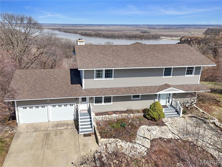 Perched high above the Mississippi River, this stunning 3,340 sq ft home offers breathtaking panoramic views and a setting that is truly one of a kind. Situated on a full acre, the property provides privacy, space, and incredible scenery that can be enjoyed from nearly every level of the home. Inside, the residence features 4 bedrooms and 4 bathrooms with spacious living areas designed to take full advantage of the surrounding landscape. Large windows throughout the home frame sweeping river views, filling the interior with natural light and creating an ever-changing backdrop. The main living spaces feature beautiful hardwood flooring and two impressive stone fireplaces that add warmth  and character. The kitchen offers abundant cabinetry and counter space while flowing seamlessly into the surrounding living and dining areas—ideal for both everyday living and entertaining. 
Step outside to enjoy multiple outdoor living spaces, including a massive deck and a screened-in porch, perfect for relaxing while overlooking the river valley. Whether hosting gatherings or enjoying quiet mornings with coffee, the views from this home are truly unmatched. With generous square footage, timeless features, and one of the most remarkable Mississippi River overlooks in the area, this property presents a rare opportunity to own a home where the scenery becomes part of everyday living. Call for your private tour today!