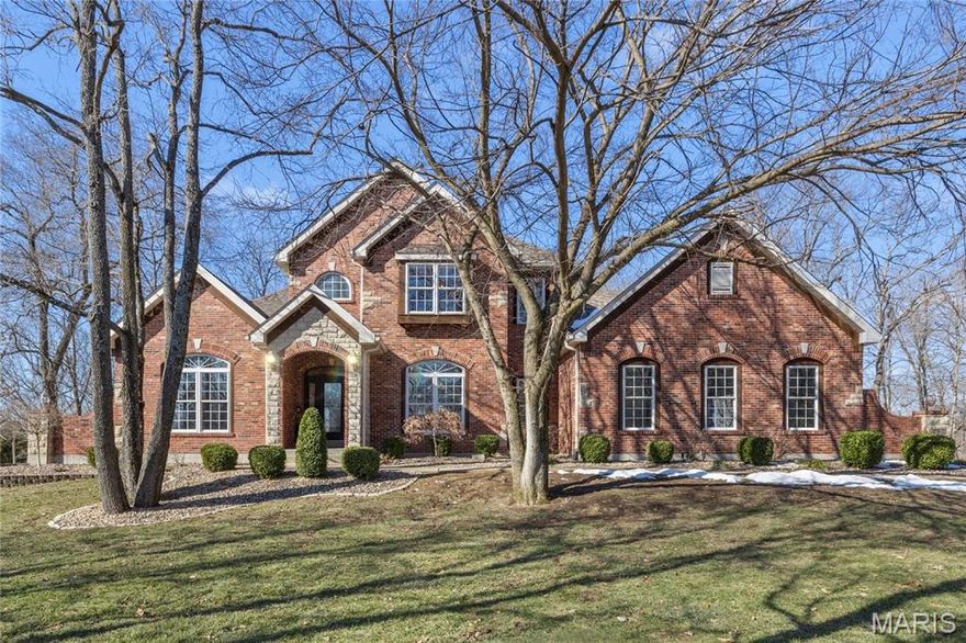 Under Contract. Open House Canceled. Elegant 1.5-story home situated on an exceptional 3-ACRE LOT with natural woods overlooking Dardenne Creek, featuring 6 bedrooms, 5 baths and a finished walkout lower level. Stately curb appeal with a BRICK AND STONE exterior, portico-covered entry, manicured landscaping, and an oversized, side-entry, 3-CAR GARAGE, which includes an EV charging outlet. This well-appointed home features luxury details: recently refinished HARDWOOD floors, grid windows and transoms, vaulted and tray ceilings, rich CUSTOM WOODWORK, crown molding, and solid wood doors for soundproofing. A soaring 2-story foyer opens to a grand dining room, across from French doors to an impressive office with built-ins. The great room provides stunning PANORAMIC SUNSET VIEWS from a dramatic wall of windows. Along with abundant natural light, a 2-sided gas fireplace and built-ins bring additional warmth to the space. Beyond the great room, there is a large, open kitchen designed for gatherings with a brick/stone fireplace, bay window, upgraded 42" wood cabinets, a BUTTERFLY ISLAND bar with cooktop, gorgeous QUARTZ counters, STAINLESS steel appliances, double ovens, and access to a large, SCENIC DECK. The main-floor primary suite features a tray/crown ceiling, bay window, walk-in closet, soaking tub and step-in shower. Upstairs, a SPACIOUS LOFT allows for flexible use. A Jack and Jill bathroom connects two of the well-proportioned bedrooms. A third bedroom and an additional bathroom finish the upper floor. The lower level showcases an ENTERTAINMENT BAR and recreation room with French doors leading to an OVERSIZED PATIO and views of an everchanging display of nature. Two more generously sized bedrooms and a full guest bathroom complete the lower level. Convenient double-door access to a basement storage area makes storing lawn equipment or patio furniture a breeze. An expansive side yard of open lawn provides ample opportunity for play and gardening. Peace of mind with a NEW ROOF. This highly-sought subdivision feels secluded, while errands are within an easy 3 miles. Just off Hwy DD and minutes from wine country, Broemmelsiek Park, O'Day Park, and the Katy Trail. In the award-winning Francis Howell School District.