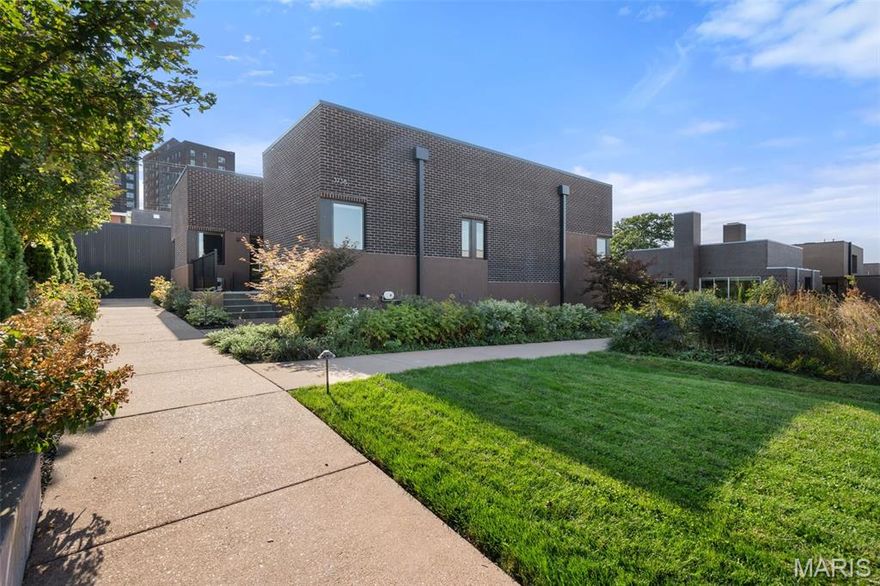 Experience modern living at its finest in this custom-built 2023 home located within On Olive, a one-of-a-kind collection of contemporary residences in the vibrant Grand Center Arts District. Thoughtfully designed and beautifully executed, this 3-bedroom, 3-bath home offers approximately 2,460 square feet of light-filled living space surrounded by curated landscaping, edible gardens, and park-like grounds. Set on one of the highest elevation lots in the community, the home’s elevated main level provides a unique vantage point and enhanced privacy. Inside, an expansive open-concept layout seamlessly connects the kitchen, dining, and living areas, creating a space ideal for both entertaining and everyday living. Floor-to-ceiling windows and multiple sliding glass doors fill the home with natural light while offering effortless indoor-outdoor flow to both front and rear patios. The designer kitchen is a true centerpiece, featuring custom cabinetry, a large island with added coffee bar, and a suite of high-end appliances including a Bosch refrigerator and range, GE dishwasher, and Sharp microwave. The space opens directly to the main living areas, encouraging connection and flexibility in how the home is enjoyed. A thoughtfully designed layout separates the main living areas from the private bedroom wing, offering two bedrooms and two full baths on the main level. The primary suite serves as a peaceful retreat, complete with a walk-in closet, spa-inspired bathroom, and private access to outdoor space. A secondary bedroom and full bath provide additional flexibility for guests or a home office. The finished lower level expands the home’s versatility with an additional bedroom, full bath, dedicated office space, and a spacious family or recreation room—perfect for a media room, gym, or guest suite. Additional highlights include a private 2-car garage with EV-ready electric just steps from the home, modern systems throughout, and a gated community setting. Residents of On Olive enjoy access to exceptional amenities including a pool with grilling area and fire pit, fitness center, clubhouse, and beautifully maintained shared spaces. Ideally located near arts, dining, and entertainment, this home offers a rare opportunity to own a modern, design-forward residence in one of St. Louis’ most dynamic and architecturally unique communities.