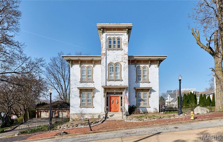 If these walls could talk, they would tell elaborate stories that encompass almost 170 years from tall tales to historical facts.  This Grand Historic Italianate style solid brick beauty was built in 1858 by James H. Johnson, a riverboat captain.  Other owners include John B Henderson (author of the 13th amendment) and Paul C Stark Sr of Stark Bros Nurseries.  This home has been lovingly preserved with the majority of original details plus modern amenities added.  Enter into the foyer through solid wood double doors and be transported back in time. Slowly make your way into the grand center hall with a view of the floating stair, glistening chandelier (relocated from the Visitation Academy of St. Louis by Theodosia Stark in 1945) and be astounded by the massive floor to ceiling mirror (relocated from the Peak Mansion in St. Louis by Captain Johnson) The majestic ballroom once used to entertain historical dignitaries boast ornate details, 2 fireplaces, walkout windows to the deck, and original interior shutters. The entire home is graced with 14-foot ceilings, and the 3rd story offers a cupola (find the hidden signatures of past owners) with a view of the mighty Mississippi River.  Enormous foldable pocket doors grace most rooms; 9 fireplaces with gorgeous mantels, and original plaster medallions ornately enhance the chandeliers throughout. Original summer kitchen was converted to a main floor suite.  Main floor kitchen was recently updated with all modern necessities. The back stairs lead to a second kitchen that once housed the indoor servants.  4 massive bedrooms with adjoining pocket doors located on the second floor each having its own fireplace.  Grand floor to ceiling library in the second-floor hall. The 2-story covered decks on the back of the home can be accessed through many doors and provide ample entertaining space.  Oversized 2-car brick detached garage with workshop area. Seasonally landscaped lot is enhanced with wrought iron fencing and original hitching post.  This stately residence has been featured on many historical tours and can easily be utilized as a B & B, wedding venue, multi-generational living, or your personal historical residence.