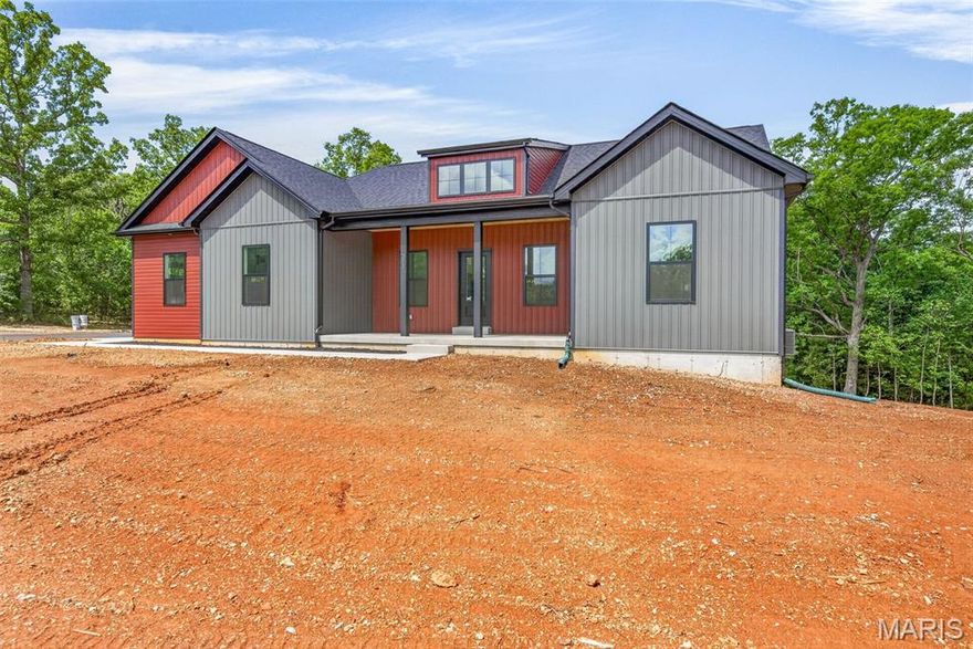 Welcome to this beautifully crafted 3-bedroom, 2-bath home offering 1,858 square feet of thoughtfully designed living space. From the moment you arrive, you’ll appreciate the home’s private setting on two spacious lots, backing to wooded acreage with no rear neighbors—providing both peace and seclusion on a newly paved street.  Inside, the home features a desirable open layout with vaulted ceilings, a large working dormer allowing ample natural light in. a large kitchen that serves as the heart of the home. It showcases custom-built cabinetry with quartz tops, large 9’ long island with a stunning custom wood top, large walk in pantry with wood tops and matching wood shelving, and a full stainless steel appliance package. Large laundry room with additional cabinetry add both style and functionality.  The primary suite is a true retreat, offering a spacious bedroom, a luxurious en-suite bath complete with a freestanding soaking tub, separate shower, and large double vanity, along with an expansive walk-in closet that conveniently connects to the laundry room. The second and third bedrooms are both nicely sized, and ceiling fans are installed throughout for added comfort.  Outdoor living is just as impressive, featuring a large deck with low-maintenance composite decking and sleek black aluminum railings—perfect for relaxing or entertaining. The home also includes an oversized two-car garage providing excellent storage or workspace potential.  Additional highlights include a full walkout unfinished basement with plumbing already roughed in for a future bathroom, a concrete sidewalk and garage apron, asphalt driveway, attractive vinyl siding, black exterior windows, and a charming wood porch ceiling.  This home offers the perfect blend of modern finishes, thoughtful design, and a quiet, private setting—ready for you to move in and make it your own.