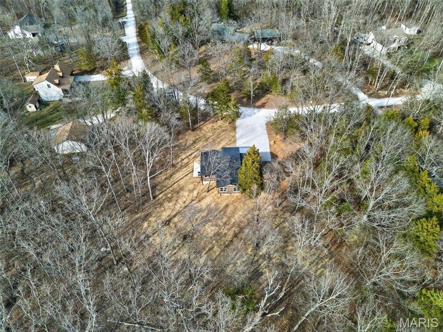 Cozy up next to the fire and watch the deer graze through your yard in this quaint, 4 bed 3 bath, fully renovated retreat in the woods!  Seated on 3 acres of partially wooded and partially cleared land, this home offers beautiful views of the woods and wildlife. In addition, to the serene views of nature, home includes access to two private neighborhood lakes perfect for fishing, swimming or hosting events at the pavilion. The home has been completely and professionally updated in each and every room. The large kitchen features quartz countertops, brand new cabinets, under-cabinet lighting, and sleek LED lighting throughout. 3 Bedrooms on the main floor, and one in the walk-out lower level are spacious comfortable. This inviting home features a stunning great room with a wood-plank ceiling, electric fireplace and serene wooded views. The neighborhood includes lake access for fishing or cooling off in the summer! Major upgrades include a new shingle roof with a black metal front porch roof, updated furnace ductwork, a heat pump, a new water heater, whole house surge protector, new copper plumbing, and new basement flooring and drain lines. An insulated, drywalled two-car garage completes the package.