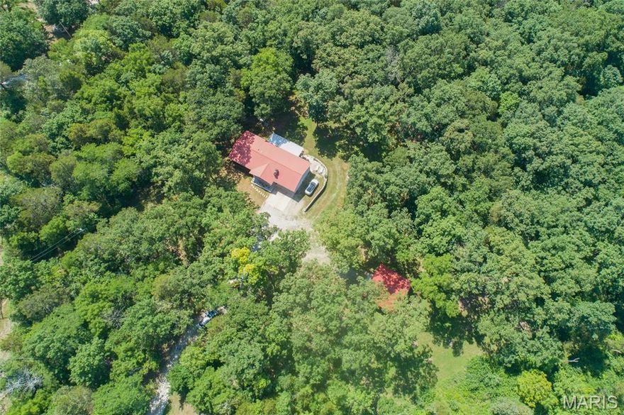 Discover serene living on 2.27 wooded acres in this beautifully remodeled open floor plan ranch that will draw you in with the Awesome Curb Appeal, Covered Front Porch and a 2 car attached Garage. With 2,024 sq ft, this home features vaulted ceilings, rich wood flooring throughout, and a stunning new kitchen with granite counters, island, custom lighting and a beautiful backsplash, this is a Cooks dream. Both full baths are completely updated, offering all the modern comforts. Don't Miss the Completely Remodeled Main Floor Laundry that is Perfect! Enjoy outdoor entertaining on the spacious covered deck overlooking the property and your backyard. A walk-out lower level and 30x30 outbuilding add versatility for storage or workshop needs, plus the metal roof on both ensures lasting durability.