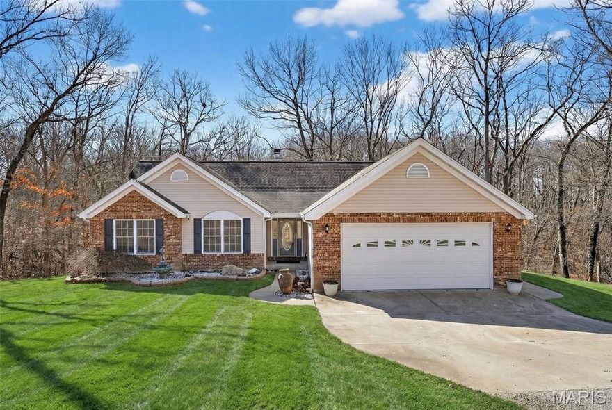 Gorgeous custom home with picturesque views on over 5 acres, offering nearly 2,000 square feet of open, light-filled living space. Vaulted ceilings, floor-to-ceiling windows, and hardwood floors lead into a spacious living room with a stunning stone fireplace. The custom kitchen features quartz countertops, a farmhouse sink, double ovens, and a large custom island—perfect for everyday living and entertaining. The primary suite is a true retreat with vaulted ceilings, a walk-in closet, garden tub, and separate shower. Two additional spacious bedrooms with new carpet, 2.5 baths, and a large laundry room complete the main level. The walk-out basement is unfinished and roughed in for a bathroom, offering endless potential for additional living space. This home has it all, sitting on 5 private acres in a gorgeous setting with deck that overlooks the beautifully wooded surroundings. Peaceful, and private this is a retreat! Professional photos on 2/23. Showings begin at the open house on 3/1/26.