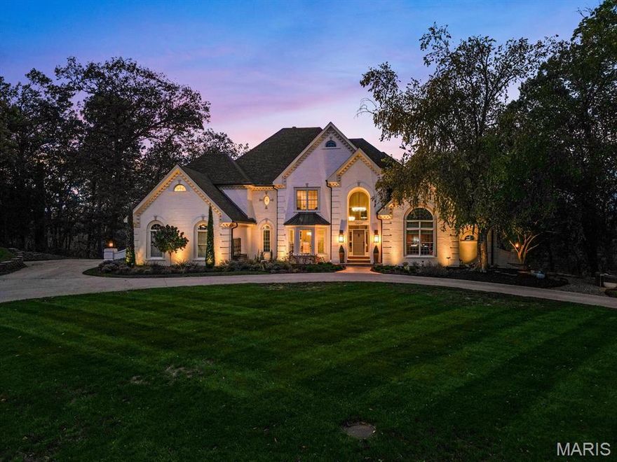 Privately positioned at the end of a cul-de-sac in the coveted Lewis Spring Farms subdivision, this extraordinary five-bedroom, four-and-a-half-bathroom estate sits on just over three acres of sculpted landscape and offers more than 8,400+ square feet of fully renovated, designer-curated interiors that deliver modern, bespoke elegance amid woodland seclusion. Redesigned entry garden anchored by a sculptural fountain guides you inside, where a dramatic two-story foyer welcomes you. Gleaming hardwood flooring carries throughout the main and upper levels, arched doorways with custom moulding frame every sightline, and a cohesive designer lighting package featuring Restoration Hardware chandeliers and Hinkley architectural fixtures adds layered warmth and emphasis throughout. The richly appointed study is wrapped in warm natural wood and showcases custom built-ins, a soaring vaulted ceiling with a statement chandelier, and an expansive arched window. The formal dining room impresses with a coffered ceiling, bay-window views, and effortless flow for gatherings from intimate dinners to holiday celebrations. The stately, two-story living room is anchored by a newly designed honed marble gas fireplace and hearth, flanked by floor-to-ceiling windows that frame serene wooded views, while custom millwork and refined signature lighting complete the composition. At the heart of the home, a newly reimagined chef’s kitchen shines with custom Shiloh cabinetry and Danby marble surfaces met with a professional, built-in stainless appliance suite: GE Monogram refrigerator with companion freezer, GE Café double oven and range with custom vented hood, two sets of refrigerator drawers, two fully integrated dishwashers, built-in microwave, and a Scotsman ice maker, engineered for prep-to-party perfection. The adjoining Hearth Room features a second honed-marble gas fireplace with easy connection to the screened porch and breakfast room. The main-floor primary suite offers a private sanctuary complete with coffered ceilings, layered chandelier lighting,  and bay windows opening to a private deck. The spa-inspired ensuite features dual vanities with lighted mirrors, Vicostone Quartz countertops, a frameless glass steam shower with integrated speakers, a separate soaking tub, and two boutique-style walk-in closets. Upstairs, three spacious bedrooms, all with walk-in closets, custom built-in shelving, and ensuite bathroom access, surround a versatile loft area suited for movie nights, games, or a cozy family lounge. The finished lower level expands your entertaining space and steps out to a spacious lower-level deck with peaceful outlooks, while the main family area delivers herringbone LVP floors, plush carpeting, a third honed-marble fireplace and hearth, and a granite-topped wet bar with a dedicated wine refrigerator. Off the main gathering space, the Poker & Pinot room delivers a tailored hideaway with custom-cut natural-wood shelving and an ambiance made for grown-up gatherings. Completing the level are a fifth bedroom, a renovated full bath, and a dedicated gym. Outdoors, sweeping lawns dissolve into woodland privacy as landscape lighting turns dusk into a show and a new Restoration Hardware gas fire pit gathers friends beneath the canopy. An extended driveway leads to a three-car garage and circular motor court, completing the estate’s polished presentation. Perfectly positioned on the Wildwood/Chesterfield border in the Rockwood School District, the estate sits minutes from Chesterfield Valley, Wildwood Town Center, and Future Downtown Chesterfield, marrying sophistication, privacy, and everyday convenience. 16907 Lewis Spring Farms Road stands as a testament to thoughtful design and careful execution: every detail refined, every upgrade purposeful, every space created to elevate how you live.