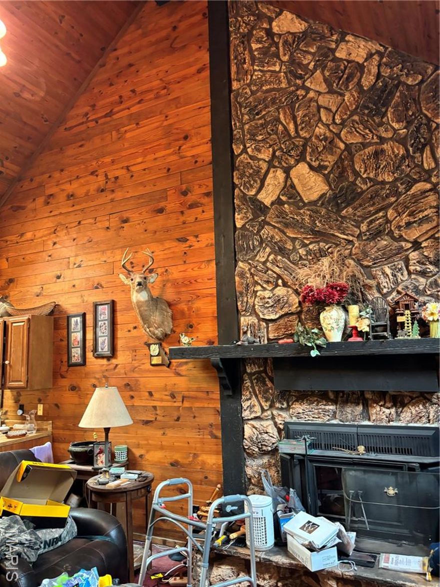 Three LOTS in Rain Tree Subdivision! This isn't just a home — it's an opportunity hiding in plain sight. The house sits on a combined 2 building lots PLUS an additional building lot into one massive parcel.  Over a full acre to dream on. Subdivide. Build. Invest. The possibilities are yours — but only if you move fast. Step inside this log home and feel it immediately — soaring ceilings, huge rooms, open-concept living that breathes. This isn't cookie-cutter construction. This is character you can't replicate. Head downstairs to the finished walkout basement — wood-burning fireplace crackling, your own private retreat waiting. Then step outside onto the jaw-dropping two-story patio canopied by mature shade trees that took decades to grow. Nature-lovers, this is your haven. Special Features include: Built in 1983, New Water Heater, New Furnace, Oversized 2 Car 
garage, Cathedral Ceilings, 3 lots totaling .84 acres, Log home with open concept + huge rooms, Finished walkout basement with wood-burning fireplace, Two-story patio with mature trees, Endless potential to build, expand, or invest,  Will provide clean sewer lateral inspection.  Rain Tree Subdivision includes:  4 Lakes, Boating, Fishing, Country Club, Golf Course, Swimming Pool, Camp Ground, Restaurant, Safety of a Secure Gated Community