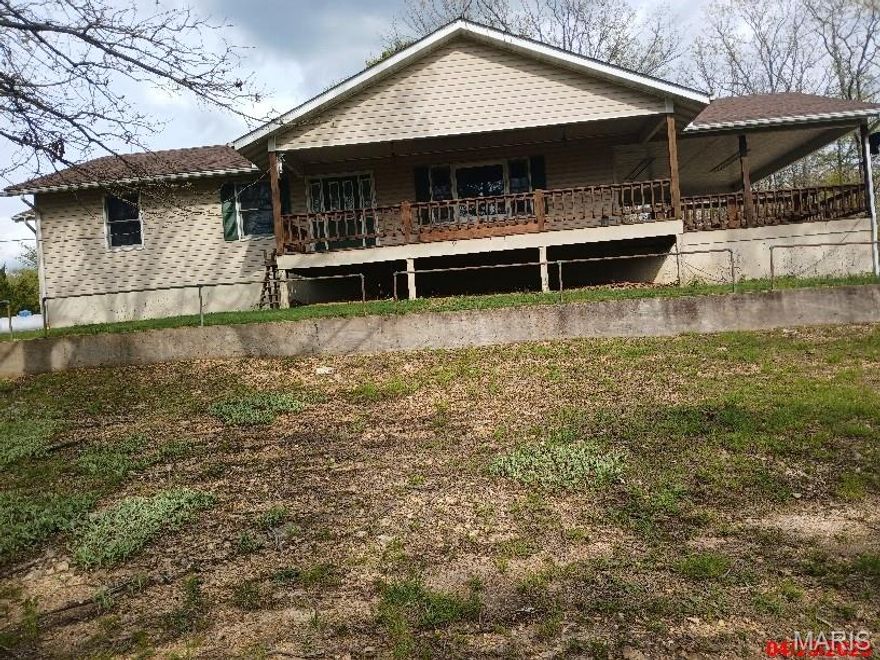 Property being sold "As Is". This ranch style home is built on a full size, fully finished basement with an exterior exit. The lower level has three sleeping areas, a living room area with wet bar, two full bathrooms, laundry room and utility space for the furnace and hot water heater. The main level entry is above ground with a covered deck entry. The covered deck has a second entry point with atrium doors entering into the open living/dining/kitchen. The main level has a half bath with sliding pocket door. Architectural built in book shelves are just inside the tiled foyer entry. Main level flooring is hardwood and has two bedrooms. The main bedroom has an open floor plan, vanity double sinks, walk-in closet, with  toilet and walk-in shower having its own privacy door. Setting on a 6 acre lot at the end of a dead end road.  There is also utility shed and covered carport under upstairs deck. Also nice landscaped yard.  MUST SEE!