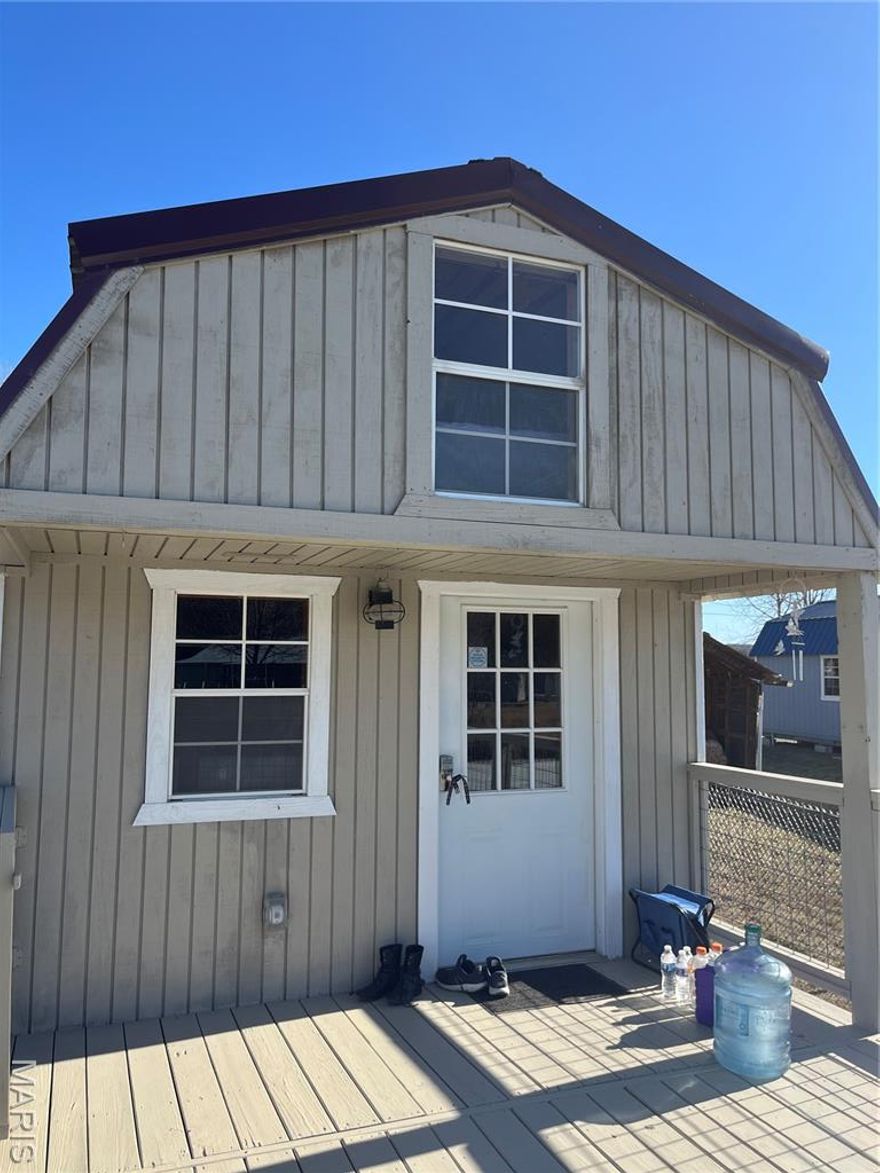 Small cabin on the water at Lake Hanna on three lots...close to one half acre. This cozy cabin is totally self contained with utilities, nice shower, kitchen area with new cabinets, portable refrigerator and microwave...room for small sofa area... ample sleeping area upstairs. Great deck overlooking water and concrete patio with firepit and plenty of room for entertaining. Fenced yard with handy electric gates with remote control.  Also included is a  12x14 "garage"  with concrete floor great for storage or lawn equipment. Wonderful get a way on the water!