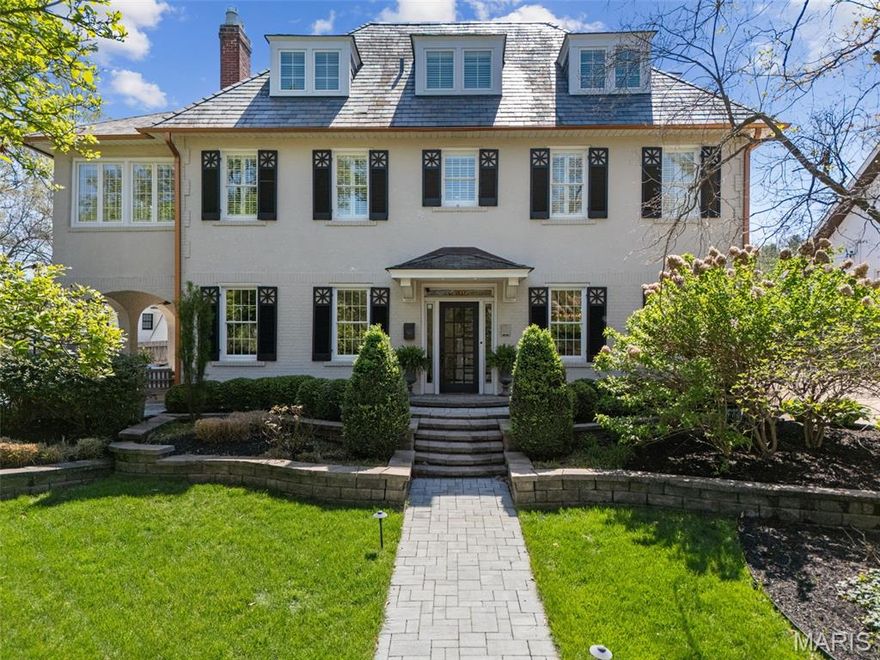 Welcome to a rare opportunity in Webster Groves’ coveted Helfenstein Park neighborhood, just a short walk to the dining, shops, and charm of Old Webster. Originally built in 1913, this meticulously preserved and fully renovated historic home offers a seamless blend of timeless architecture and modern luxury. As only the fourth owner, the next steward will carry forward a legacy of thoughtful care and preservation. Recognized with a Historic Preservation Award, the home offers 3,477 square feet of finished living space across 2.5 stories, including 5 bedrooms and 3.5 baths. The elegant original staircase sets the tone upon entry, anchoring a gracious foyer and showcasing the home’s historic character. The spacious living room features a woodburning fireplace flanked by French doors that open to a covered patio with arched openings, leading to an additional patio and professionally landscaped grounds—creating a seamless indoor-outdoor connection ideal for entertaining. The kitchen is designed for both everyday living and elevated entertaining, featuring custom cabinetry, premium Wolf, Sub-Zero, and Bosch appliances, and a striking 9' x 4' Danby marble island with seating. An adjoining butler’s pantry extends the space with matching cabinetry and high-end finishes, providing exceptional function and storage. Extensive renovation updates include all-new electrical and plumbing, a slate roof, and energy-efficient geothermal heating and cooling-delivering long-term efficiency, comfort, and peace of mind. The primary suite offers a true retreat, highlighted by a 300 sq ft spa-inspired bath finished in Carrara marble, including marble floors, a marble shower, elegant half-height marble walls, and a soaking tub. A private 130 sq ft balcony extends the suite outdoors, creating a rare and serene escape. Four additional bedrooms are thoughtfully distributed across the upper levels. The second floor includes two additional bedrooms, a beautifully appointed full bath with marble floors, and a finished sunroom offering flexible space for an office or sitting room. The third floor features two more bedrooms and a full bath with a walk-in shower and marble floors—ideal for guests or private living quarters. The unfinished lower level has been enhanced with a lowered floor providing approximately 7-foot clearance and rough-in plumbing for a future bath, offering excellent potential for additional finished living space. A rare combination of historic character, award-winning preservation, and refined modern updates, all in one of Webster Groves’ most desirable and walkable locations.