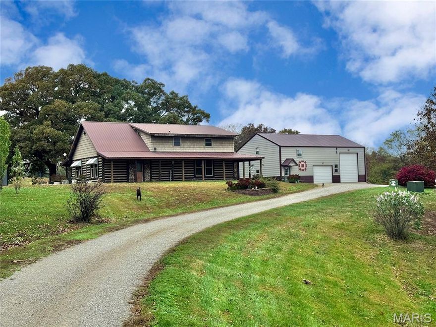 PRICE REDUCED! Open House, Sunday, January 18, 1-3pm. Discover your ultimate private retreat at 24129 Granite Avenue in Lewistown, MO, where rugged charm meets modern convenience. Just off the blacktop, a discreet drive leads you to this impressive property, featuring a tranquil pond, a versatile shouse, metal building, and a striking white oak log home. The commanding wrap-around porch invites you to envision invigorating mornings with a cup of coffee while wildlife roams nearby. Inside, the grand foyer opens to a spacious living room with vaulted ceilings, perfect for unwinding or hosting movie nights. The formal dining area, complete with a custom chandelier, sets the stage for memorable gatherings. The kitchen is equipped with stainless steel appliances and an island, complemented by stunning country views from the French doors. The main floor primary suite boasts two walk-in closets and a luxurious bath featuring a jetted tub and stand-up shower. Upstairs, you'll find a cozy common area, two additional bedrooms, and a full bath. The adjacent shouse serves as the ultimate entertainment space, featuring a kitchen, full bath, and loft area for sleeping or lounging. Plus, the expansive shop includes a 9,000lb lift for all your projects, while an additional metal building offers ample storage for equipment or overflow. With pasture ready for livestock and summer adventures waiting at the pond, this exceptional property is a man's dream come true—don't let it slip away! *The windmill is not included in the sale.
