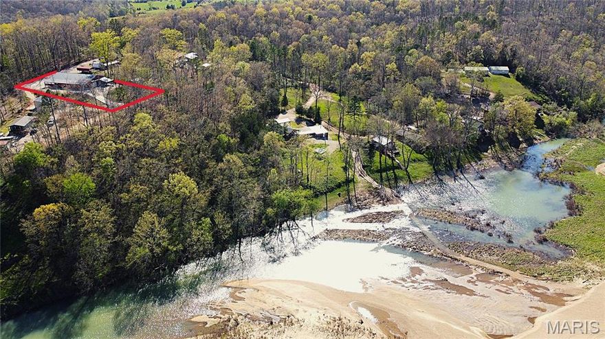 Custom Barndominium w/ private Current River access for sale in Van Buren, Missouri - This unique and versatile build is spacious, efficient and low maintenance, offering a variety of living arrangements for the full time resident or the weekend escape. Located in River Running subdivision, you enjoy private, gated access to one of the top 3 gravel bars along the middle Current, in addition to paid Deer Run privileges.  There are essentially 2 homes under one roof: The rear portion of the home offers a full kitchen, living room, formal dining room and an office that could be utilized as another bedroom. The primary bedroom features a generous combo bath / closet complete with WD hookups and ample storage. The river side of the home is set up for river weekends and entertaining, with an additional full kitchen, large living area and 2 more guest suites with full baths and built in bunks easily accommodating 10+ guests.  Approx. 2500ft of covered parking for your toys. Too much to list. Suitable for Bed/Brk