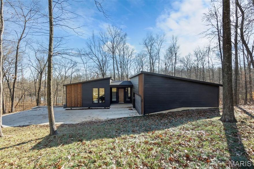 Stunning modern and cozy home nestled on a private 3.2 acre wooded lot. This 4 bed, 3 bath homme has wood floors and 10' wood ceilings throughout the main level and breathtaking views of the outdoors in nearly every direction through the 8' tall black Andersen windows. You'll find sleek concrete countertops in the kitchen and bathrooms and a jacuzzi tub and walk in tile shower with rain shower head in the primary bathroom. The basement offers a family room, bedroom, bathroom, and giant John Deere room. The exterior of the home is a gorgeous mix of smart siding and wood siding, with a covered composite deck that also boasts a wood ceiling. Come see your private oasis today!