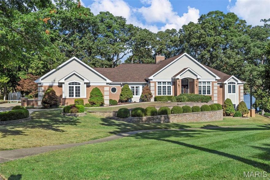 VIEW from every window - gorgeous view of the big Lake St Louis Lake is what you see from this wonderful custom home. The covered deck extends across the back of home to allow you to watch the holiday fireworks or simply sit back & relax at your own lake front retreat. Beveled glass entry doors begins your tour, soaring ceilings, arched door openings, desirable split bedrm floor plan and an ELEVATOR that services all floors. Formal dining rm-coffered ceiling, home office or 4th bedrm on the main level with & glass doors.  Wall of windows, cozy fireplace in the great rm. The light and bright kitchen & breakfast room, updated counter tops, stainless appliances, walk in pantry, tall ceilings & breakfast bar. Primary suite is highlighted w/turret ceiling, wall of windows~wake up to the lake view & access to deck, luxury bath. 2 additional bdrms & full bath on main level. The LL offers a family rm w/walk out and see-thru fireplace, 4th full bath, media rm, 3rd fireplace. 3 car garage.