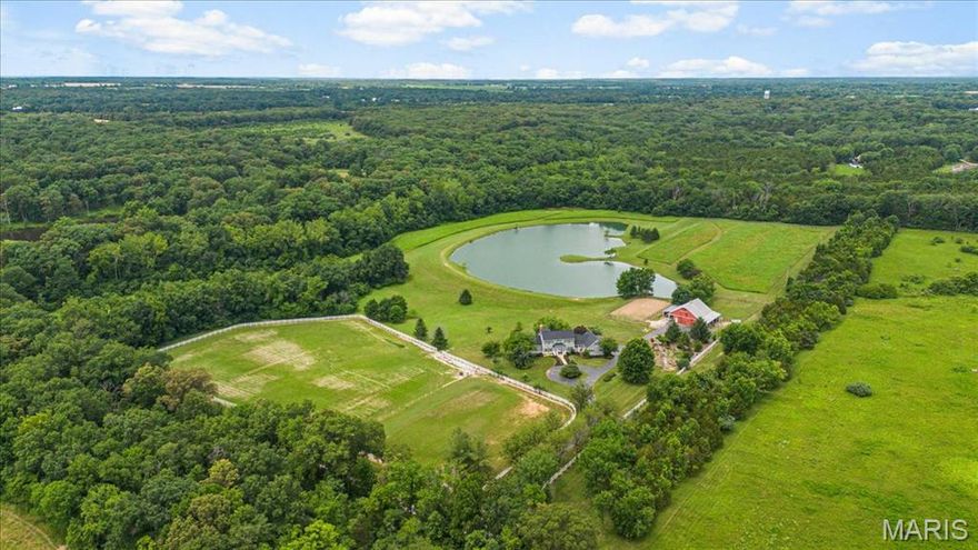 This private, fully outfitted equestrian/homesteader/fishing property features 28+/- level/gently rolling acres with a 5+/- acre stocked pond, 4,656+/- SqFt 1.5 story custom home, 48’x35’ barn w/electricity & water, outdoor riding arena & pastures. A tree lined driveway leads to a charming 5 bedroom & 4 full & 1 half bath home with 3-car attached garage. NEW roof & HVAC (2024). Living room features wood flooring, brick gas fireplace, 13’+/- vaulted ceiling w/wood beams & built-in bookcases. Eat-in kitchen with custom cabinetry, stainless steel appliances, wood flooring, granite counters, butler’s pantry & walk-in pantry. Primary suite with wood flooring, large walk-in closet & an updated bath boasting a custom double sink vanity, custom shower, freestanding tub, & towel warmer. Dining room, bedroom/office, mudroom, laundry room & sunroom complete the main level. Upper level extends living with 2 bedrooms with carpet, walk-in closets, & share Jack&Jill and sitting area. Walk-out lower level with a family room with wet bar, stone wood burning fireplace & built-in bookcases, 5th bedroom, full bath & unfinished storage. MUST SEE!