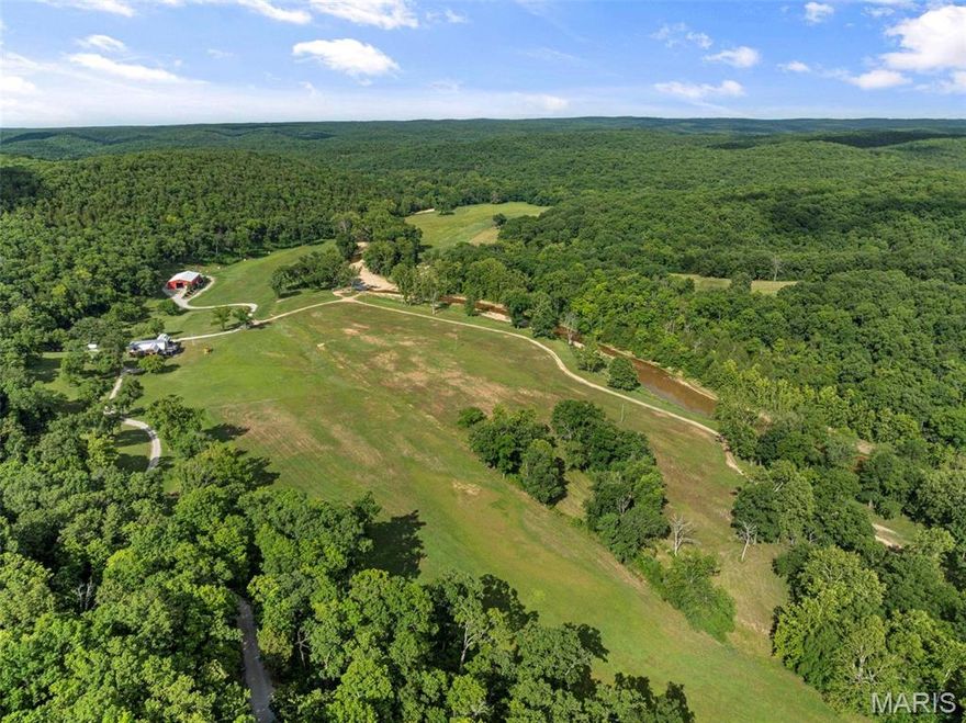 Situated roughly an hour and fifteen minutes SW of St. Louis, amidst the picturesque landscapes of the Missouri Ozarks, lies the Indian Ridge Creek Ranch. With a sprawling 620± acres, this property is a testament to serene living and architectural innovation. One of its main highlights is the meticulously restored dairy barn, transformed into an opulent residence with 7 bedrooms and 4.5 bathrooms, capable of accommodating up to 22 guests. This residence combines rustic charm with modern comforts, from its expansive living room and kitchen area to its spectacular downstairs bar. The ranch is the perfect place to entertain for business or family. 

The 6K± SQ FT machine shed is the ultimate in "man" caves. The ranch proudly hosts 1+/- mile of the flowing Indian Creek. For hunting enthusiasts or nature lovers, the land is abundant with wildlife, augmented by its adjacency to thousands of acres of Missouri Department of Conservation land on three sides of the farm.