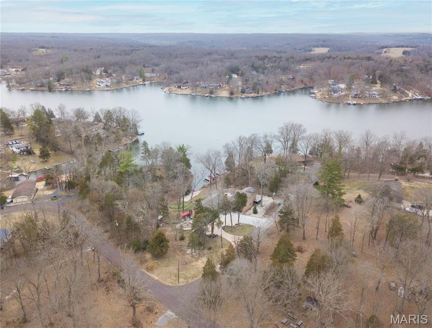 Imagine Living where Others Vacation.  Whether you are looking for a full-time residence or a weekend retreat, we offer the perfect blend of nature and convenience! Lake Tishomingo is a private gated  225-acre lake community approximately 20 minutes from St. Louis County.-- or 30-60 minutes from anywhere in the St. Louis Region but a World away from the pace of the city.  It offers year round resort-style living with boating, kayaking, fishing, swim areas, beach areas, seasonal security patrol, a clubhouse, picnic pavilion along with a gigantic BREATHTAKING private lake.  It allows motorized boats and features boat launches, docks and recreational areas.   This lovely home offers you Comfort and Tranquility. It feels like a weekend getaway Everyday. 5 bedrooms, 5 full baths and 1 half bath.  And there's still room to spare! Lots of windows, Two fireplaces, Roomy bedrooms, 3 of them have private bathrooms, decks galore, plenty of parking, PRIVATE DOCK  (with boat lift) with space for two boats.   Lots to see when you are viewing this house.  
Here's the Rest of the Story:  Original Home was completely torn down in 2004.  In 2010 - Did the new addition which included the hallway to the oversized climate-controlled 4-car drive-through garage and the two upstairs bedrooms with the private deck and bath.  In 2020- the BIG addition was made--the primary bedroom, Luxury bathroom, two large walk-in custom closets, & large expansive deck overlooking the lake.  Underneath of this addition, the large family room with wood stove  and it's own HVAC along with an additional full bath and a small bedroom was built for lake living and entertaining ease.  Guests will love the three composite decks, the custom paver terrace patio, hot tub, new golf chipping green with putting area & PRIVATE  dock for two boats --All of which make this home even more appealing for tons of  fun/relaxation.  Visit  http://www.laketishomingo.com regarding amenities, rules & regs.