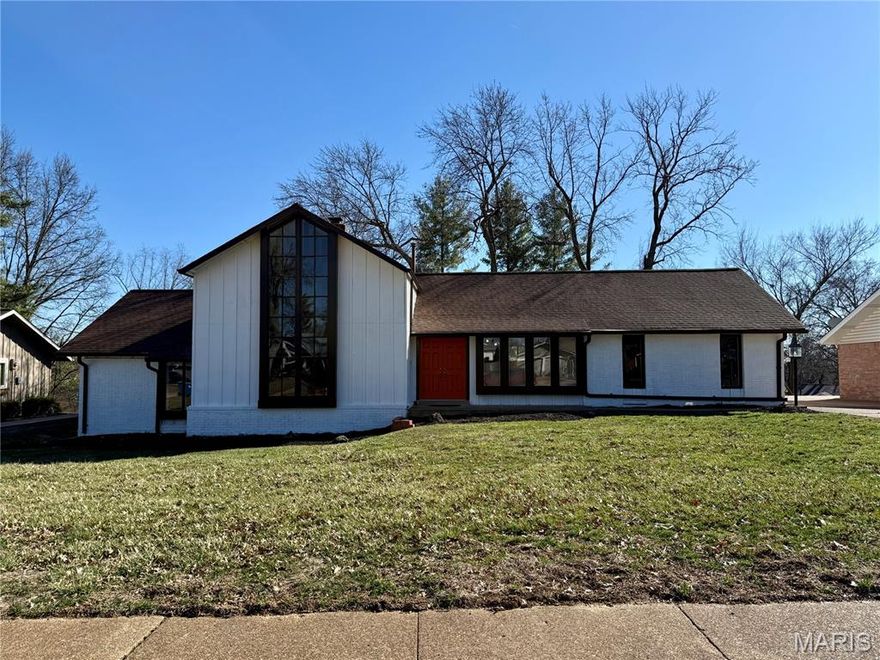 In the heart of Ballwin, where quiet streets wind beneath mature trees and mornings arrive softly with birdsong, there stands a home that feels as though it were plucked from the pages of a modern fairytale. Its story begins as you enter the front door, where new oversized tile floors shimmer, guiding you inward. To your left, in the front living room, sunlight spills through generous windows and dances along soaring ceilings, drawing your eyes upward to exposed beams that crown a magnificent two-story living room. Here, a grand wood-burning fireplace flickers at the center of it all, shared on both sides like a secret between the living room and the cozy family room beyond. Above, a striking modern chandelier glows like a constellation, setting the tone for evenings filled with warmth and wonder. Should you desire a quiet corner for imagination or productivity, the front living room offers endless possibilities. Perhaps it becomes a library lined with well-loved novels, a refined study, or a sunlit home office where inspiration arrives daily. The heart of the home beats strongest in the open-concept kitchen and dining space—an inviting gathering place reimagined with thoughtful care. Brand-new cabinetry stands crisp and elegant, quartz countertops shimmer softly, and a generous island with bar seating waits patiently for morning coffee conversations or late-night storytelling. Just steps away, a rear-entry two-car garage ensures that returning from shopping adventures is effortless and your groceries can be carried in with ease. Ascend to the private upper level and discover a primary suite that feels like a retreat hidden among the treetops. Vaulted ceilings with exposed beams echo the home’s architectural charm, while a large picture window frames tranquil woodland views. Double closets offer generous space, and the beautifully updated bath provides a spa-like haven where the day begins and ends in serenity. On the main level, down a hall adorned with beautifully refinished hardwoods, two additional bedrooms await—spacious, welcoming, and ready to adapt to dreams of their own. A fully renovated hall bath serves them with both style and function. Below it all lies a canvas of opportunity: an unfinished lower level with soaring nine-foot ceilings, dual HVAC systems, and a laundry area. Whether envisioned as expanded living quarters, a recreation retreat, or abundant storage, this lower-level space patiently awaits its next chapter. Step out back and you’ll find yet another quiet delight. A shaded patio overlooks peaceful trees, offering privacy and calm for morning coffee or twilight reflection. Here, nature lingers close, yet the conveniences of modern life remain wonderfully nearby. Situated within the highly regarded Parkway West School District and just moments from shopping, dining, and easy access to Highway 141, this home blends storybook charm with everyday practicality. Some homes simply provide shelter. Others invite you to imagine the life you might live within their walls. This Ballwin treasure does the latter—whispering of cozy winters by the fire, sunlit afternoons beneath vaulted beams, and a future waiting to unfold. The next chapter is ready to be written. Will you be part of the story? Roof is approximately 1-year old and siding has been replaced.