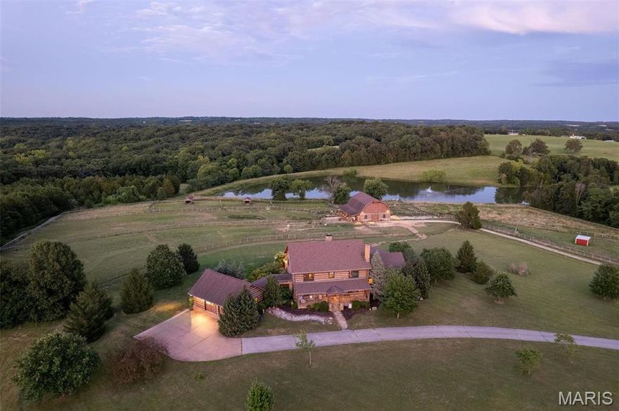 Magnificent Custom Hearthstone hand-hewn log home is the hallmark of this one of a kind country estate. The custom design and craftsmanship are breathtaking! Beautiful soaring vaults in the timber-filled great room are accentuated by the masonry stone fireplace. The chef's kitchen is truly state of the art with Viking appliances, copper sinks, chisel-edged granite counters, huge center island and more. Separate dining room features built-in serving pantry. Off the entry foyer you'll find the study/den with stone fireplace. Luxurious primary suite is phenomenal and the perfect place to retire to at the end of the day with walk-in closets, 2 full baths, laundry and sun room. Upstairs two additional bedrooms share a full bath and a Loft to use as you please. Multi-level stone deck w/built-in grill is relaxing. Barn complements the style of the house with massive loft, conditioned multipurpose room, full bath. Five fenced fields connect to the barn, stocked lake. Additional Rooms: Mud Room