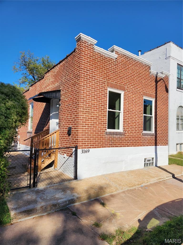 View of home's exterior featuring a gate and brick siding