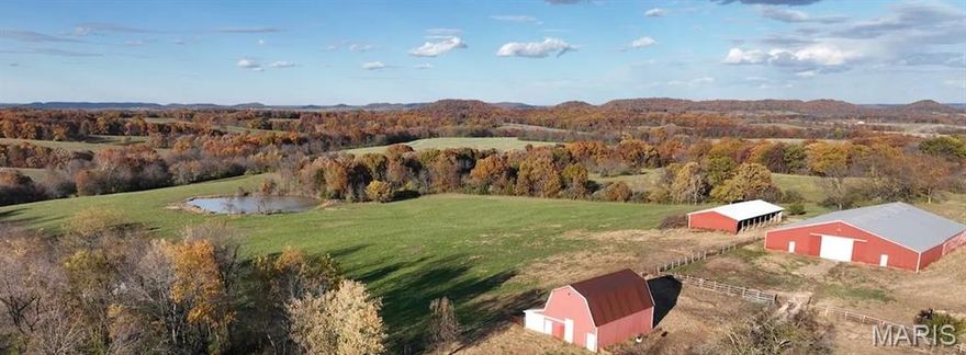 Experience the rare combination of scenic beauty, functional improvements, and strong income potential on this one-of-a-kind 28± acre equestrian property in the highly regarded Pike County knobs, just minutes from Eolia and US-61. This exceptional property features sweeping horizon-wide views that are increasingly hard to find, making it an ideal location for a luxury equine estate, boarding operation, event venue, or multi-use rural investment.

A long, secluded driveway leads through serene countryside to the heart of the farm, where utilities are in place and multiple build sites await your vision — from a custom home or barndominium to future expansion opportunities.

Outstanding Improvements & Income Potential:
• 115’ x 90’ Equestrian Barn with 20 stalls and a massive indoor riding arena — perfect for boarding, training, lessons, or clinics.
• 40’ x 78’ Equipment/Hay Barn offering abundant storage for hay, vehicles, and gear.
• Classic Red Livestock Barn with loft — adds both utility and timeless rural character.
• Comfortable Bunkhouse (1 bed/1 bath with kitchen and living area) — ideal for staff housing, guest quarters, weekend stays, or short-term rental income.

Land & Lifestyle Features:
• Rolling, open pastures with perimeter fencing — perfectly suited for horses or livestock.
• A picturesque pond that enhances both function and aesthetics.
• Elevated terrain capturing panoramic countryside views that create dramatic backdrops for events, photography, or peaceful living.
• Multiple great building sites with utilities already onsite.

Whether you’re looking to establish a full-service equestrian facility, develop a unique event destination, generate strong rental income, or create a retreat with long-term value, this property delivers versatility, quality, and location rarely offered on the market.

This truly distinctive property is a must-see — schedule your private showing today.