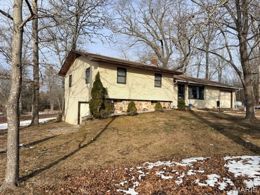 Beautiful 3-bedroom, 2-bath home located inside the city limits on a rare and massive 2-acre lot. This home features central heat and air with a wood backup, fresh interior paint, and new carpet throughout. The partial walk-out basement offers added space and versatility, while the sunroom provides a perfect spot to relax and enjoy the peaceful surroundings. An attached garage and convenient circle driveway add to the home's functionality. Tucked away in a private, off-the-street setting with mature, beautiful trees, this property offers the best of city living with a quiet, country feel.