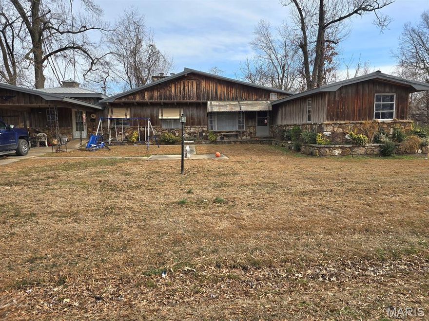 Check out this 3-bed/2-bathroom home for sale in Dexter.  It has a large living room and a family room/den with a wood burning fireplace.  The family room/den is next to the primary bedroom en suite and has doors which can be shut off from the main part of the home for your own private oasis.  The kitchen has an area for a table and around the corner is an area perfect for another small table for those larger family gatherings.  A ton of natural wood throughout on floors and ceilings.  A separate laundry room includes a laundry sink and added cabinets.  Outside, you will find a covered carport connected to the front of the home and a detached, covered carport/outbuilding, a large side yard, and Dexter Creek runs along the back yard.