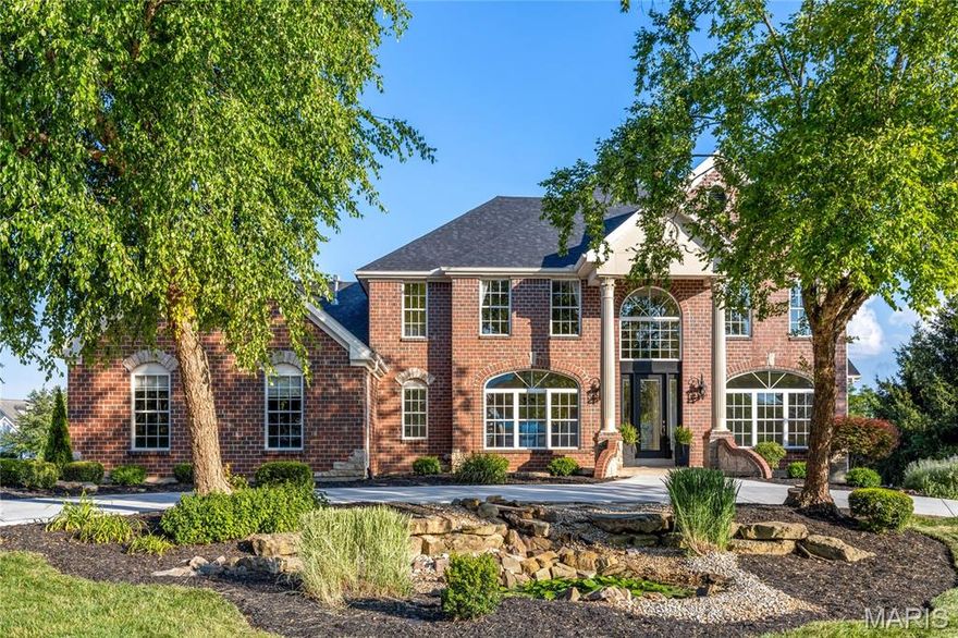 Stately brick & stone Georgian Colonial in prestigious Camelot. Impressive 2-sty porch entrance with architectural columns & wing walls leads to marble foyer, private study, elegant dining room and spectacular great room with wet bar & marble fireplace flanked by 2-sty palladian windows that overlook parklike backyard. Designer kitchen featuring 42” custom cabinetry, quartz countertops, premium appliances & 5’ center island adjoins breakfast room with convenient planning center & exceptionally large, light-filled hearth room with cathedral ceiling & floor-to-ceiling stacked stone fireplace. Coffered primary bedroom suite with 2 walk-in closets & luxury bath with jetted tub offers an appealing retreat. T-staircase accesses 3 additional bedrooms, 2 with Jack n’ Jill bath, office & hall full bath. Lower Level entertainment space includes recreation room with stacked stone fireplace, game room & media room plus 2nd kitchen & guest suite. Situated on a 1.14-acre lot with deck, covered patio, koi pond & 3-car garage.