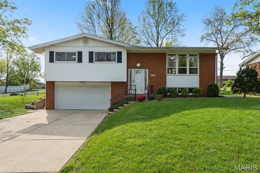 Opening Day ‘26 may have come and gone, but 5100 Caribee is still battin’ a thousand. This isn’t Big Mac Land… but it’s pretty darn close. This 1960s split-level in Mehlville brings 3 beds, 3 baths, and over 2,000 sqft on nearly *half* an acre. Strong curb appeal right out of the gate with a large driveway and classic exterior that holds its own. Step inside and you’re greeted with hardwoods and a split foyer that lets you call the play, up or down. Upstairs, the living room is bright and open with large double-hung windows that keep things light all day long. It flows right into this dining room, ready for dinners, holidays, or whatever you’re hosting next. The kitchen has been renovated with white cabinetry, quartz countertops + a glass backsplash that actually makes you stop and look. There’s even a peek-through window into the bonus room, which might steal the show. New flooring, built-ins + windows everywhere make it perfect for a playroom, office, gym or extra hangout space. Three spacious bedrooms sit on the main level, including a primary suite with a full en-suite that brings the pink tile and a walk-in shower that just works. The hall bath leans into the butter yellow charm in the best way. Downstairs, the lower level is your cozy go-to with built-in bookshelves, plenty of storage + the MVP… a gas fireplace with unlacquered brass details. Feels like the perfect spot to catch a game or settle in for the night. There’s also another full bath down here, which is a rare win. Laundry is tucked away and ready for whatever setup you want next. Out back, you’ve got a walkout patio, and a fenced in yard that keeps going in the back & on the side!  Corner lot, tons of green space + room to do entertain like you’re in those all-you-can-eat seats at Busch, no one telling you to slow down. Quiet neighborhood, great neighbors, easy access in n out + close to all the local staples, like Liliana’s Italian Kitchen, Bartolino’s South, Trattoria Toscaso, Salt + Smoke, and so many more. Bonus? Brand new roof in 2025! This one plays the full nine. Cheers!
