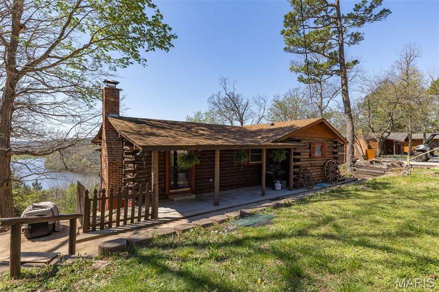 Charming 2 bed, 2 bath log home nestled in the Grayhawk lake community with stunning year-round lake views. This well-maintained property features an open floor plan with spacious living, dining, and kitchen areas, perfect for entertaining. The main floor offers a private primary suite with full bath and direct access to the expansive wrap-around deck, ideal for enjoying the peaceful surroundings. The finished lower level includes a large family room, second bedroom, full bath, and laundry area, with walk-out access to a patio overlooking the lake. The property also includes a level front yard, additional outdoor entertaining space, and a storage shed for lake and recreational equipment. Located in a private community offering lake access and amenities, this home is perfect as a full-time residence, weekend retreat, or investment opportunity. Sellers are still in the process of sprucing everything up for the new owners. They are scheduled to receive new flooring in the basement and new railing around the outside lower deck. Professional photos coming 4/6/26.