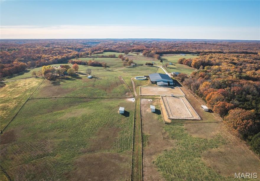 Whispering Creek Farm A Premier 70-Acre Equestrian Estate.  Welcome to Whispering Creek Farm, a state-of-the-art, 70-acre horse facility thoughtfully designed for professional equestrian training, boarding, and competition. This remarkable property combines first-class amenities with exceptional functionality making it ideal for dressage, boarding, or any equine discipline. At the heart of the property is a 165’ x 115’ covered riding arena featuring premium rubber and sand footing, energy-efficient LED lighting, an integrated sound system, and an impressive 50 feet of mirrors to enhance training precision. The arena is attached to a 10-stall stable, each 14’ x 14’ concrete stall boasting beautiful exposed aggregate fronts, built-in hay and feed bunks, a wash bay with hot and cold water, a feed room, and a tack room. Additional facilities include a 40’ x 60’ hay barn, an 8-stall horse barn, and a 24’ x 32’ barn with 4 stalls, providing ample space for horses and equipment. A 14’ x 28’ office with a kitchen and full bath offers comfort and convenience for staff or clients. Outdoor amenities feature two large riding arenas 150 x 250 and 100x 250 perfect for training and events. The farm includes nine paddocks with automatic waterers five of which have run-in sheds. A grain elevator, shavings shed, and two wells further enhance the property's self-sufficiency. For recreation and relaxation, enjoy approximately two miles of private riding trails winding through the scenic landscape. Whispering Creek Farm is expertly set up for a professional dressage operation but is perfectly adaptable for any equestrian discipline. Every detail reflects quality, functionality, and a passion for horses.