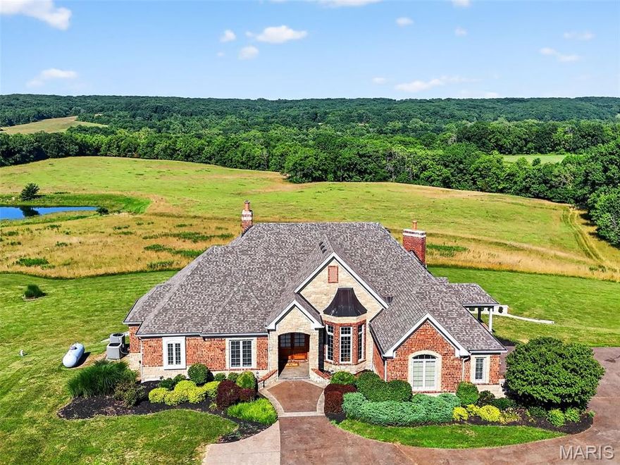 Welcome to this luxury atrium ranch situated on 29.93 acres of stunning, private land, currently in pasture, complete with a 2-acre lake and an abundance of wildlife—an outdoorsman’s dream come true. This beautifully designed 3 bedroom 3.5 bath home offers over-the-top comfort and style with a thoughtful layout, perfect for everyday living and entertaining. The main floor features 2 bedrooms and 2.5 baths, including a spacious primary suite with a coffered ceiling, walk-in closet, and a luxury ensuite bath featuring dual vanities, soaking tub, and separate shower. The gourmet kitchen is equipped with a large center island, stainless steel appliances, and a breakfast nook for casual meals, in addition to a formal dining room for entertaining. Enjoy the warmth of two fireplaces—one in the hearth room and one in the great room—as well as rich hardwood floors throughout, main floor laundry, and a dedicated office space for remote work or study. The fully finished walkout bsmt features a large rec room with fireplace, bar, wine cellar, sitting area, exercise room, a bedroom, and a full bathroom—offering endless possibilities for guests or extended stays. Step outside to relax on the covered deck or entertain on the beautifully crafted stamped concrete patio overlooking the peaceful acreage. A spacious 3-car garage adds functionality to this stunning property. Whether you love to entertain, explore, or simply enjoy the quiet of country living, this one-of-a-kind estate has it all.
